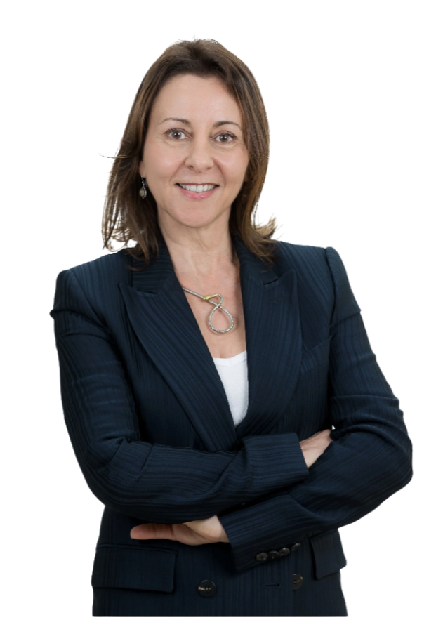 A woman smiling, wearing a navy blue pinstripe blazer and a necklace, with her arms crossed.