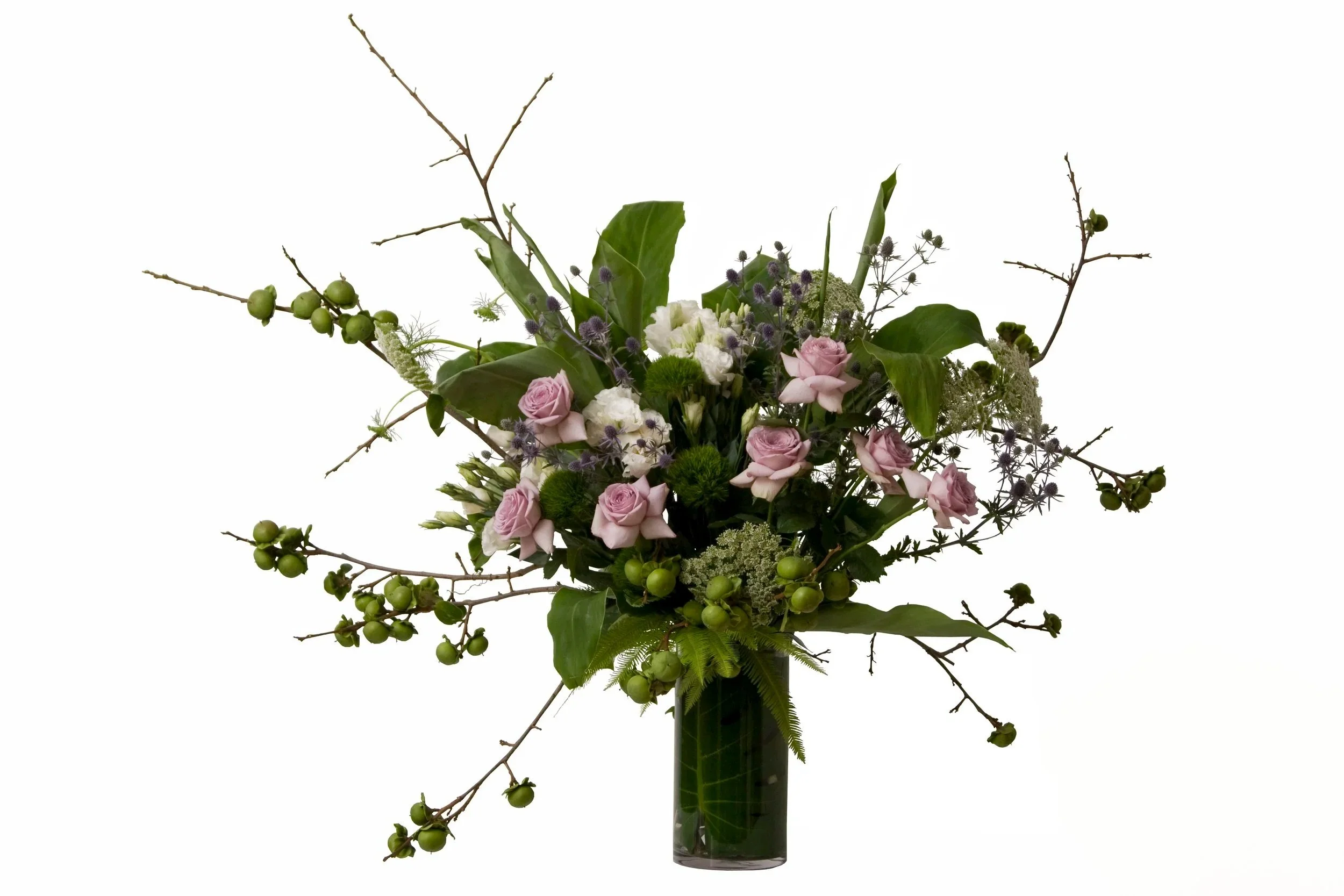 Floral arrangement featuring blue sea holly, white lisianthus, mauve classic roses, white queen anne's lace ginger foliage and persimmon. Botanic Flowers 1300 820 920.