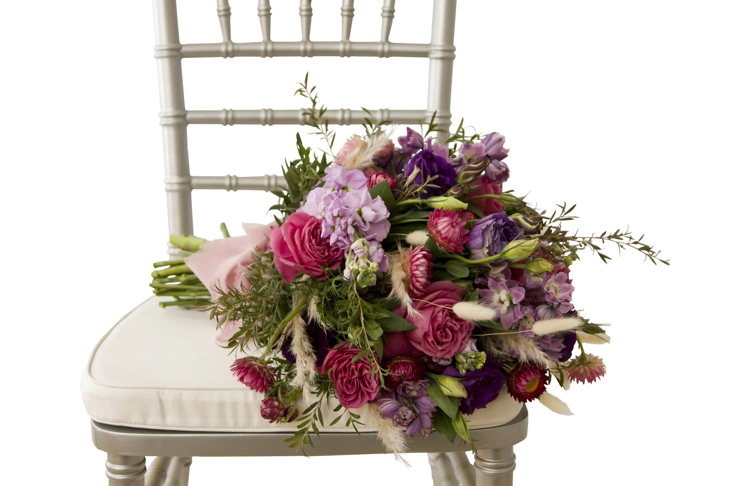 Wedding Flower bouquet featuring mauve stock, burgundy strawflower, pink roses, mauve delphinium, purple lisianthus, ti-tree foliage and natural bunny tails. Botanic Flowers 1300 820 920