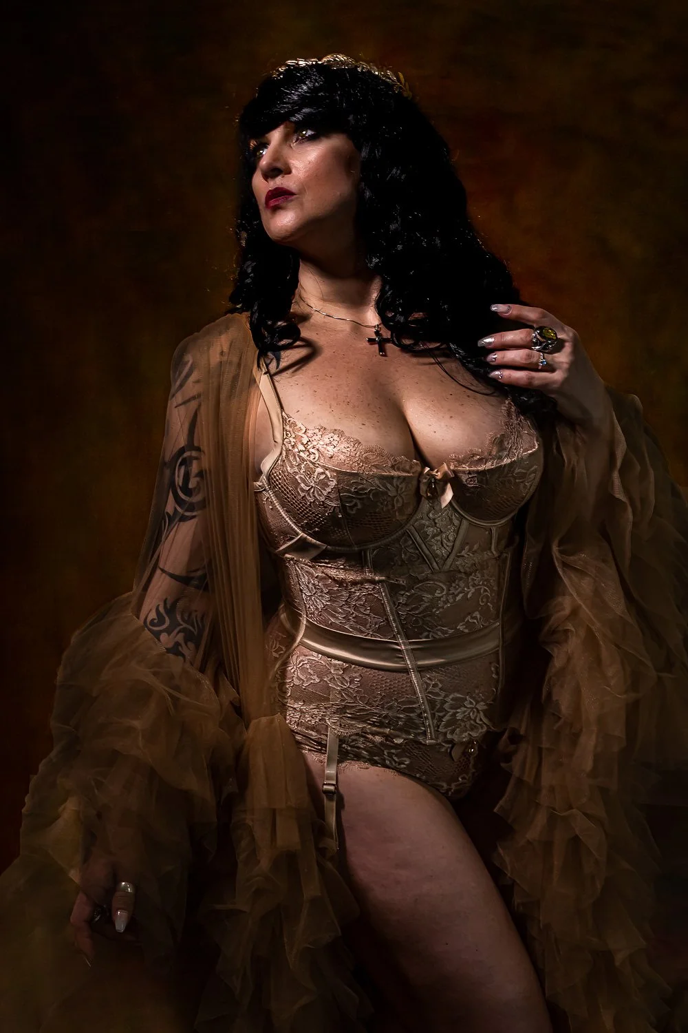 Curvy woman in a gold lace bodysuit and fur wrap posing in warm studio light in Bangor, Maine