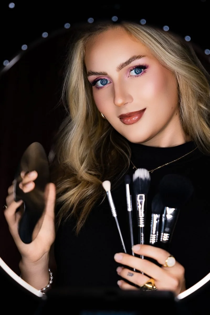 Jacalyn Rae, hair and makeup artist for T3 Portraits, holding her makeup brushes