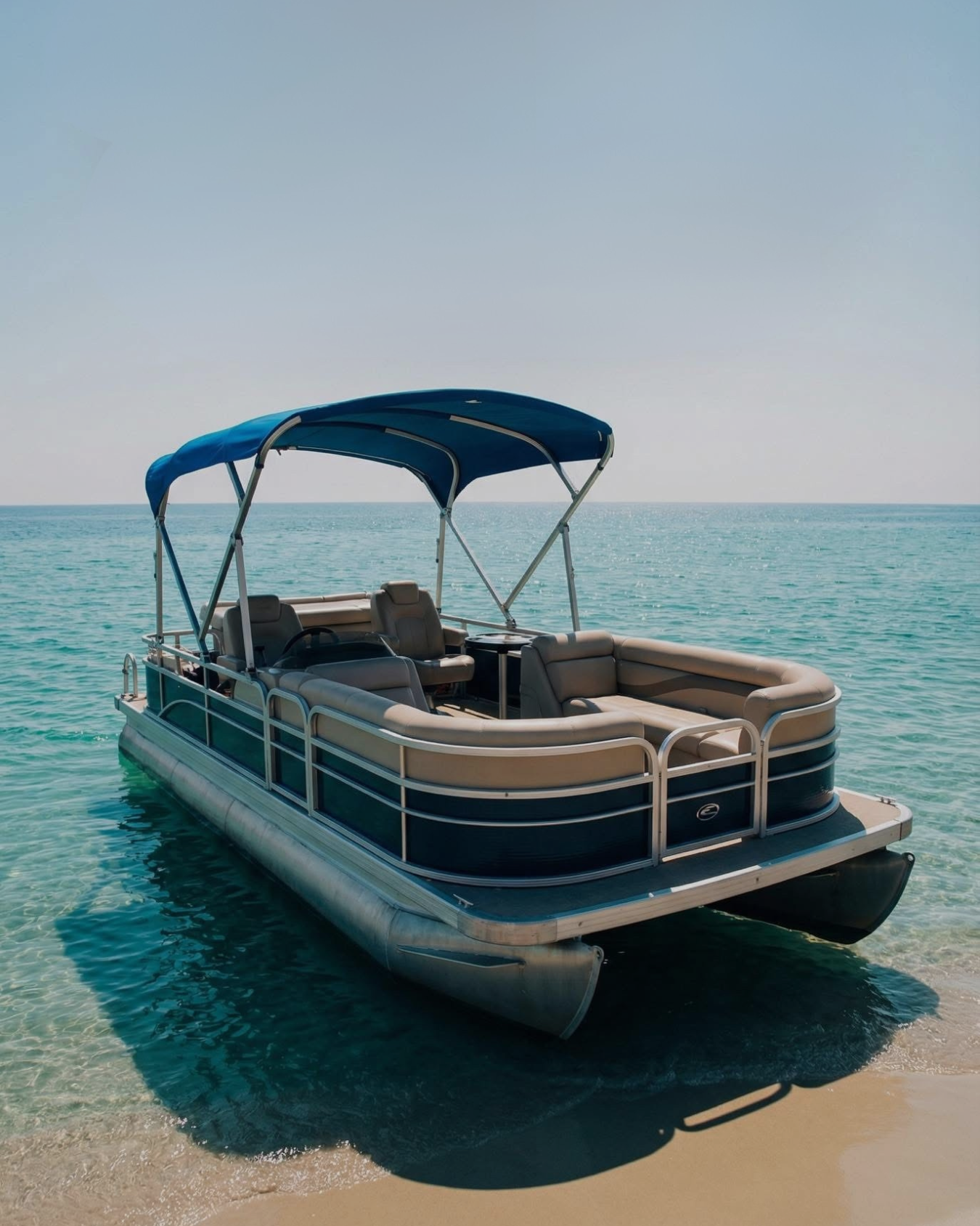 A family of three sitting on a boat docked by a marina with water and houses in the background, under a blue sky.