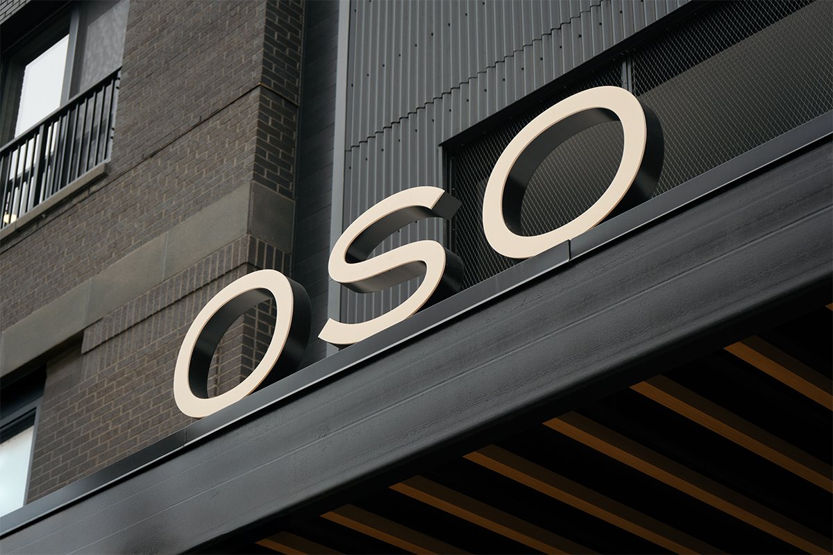 Exterior sign with the letters "OSO" mounted on the building facade.