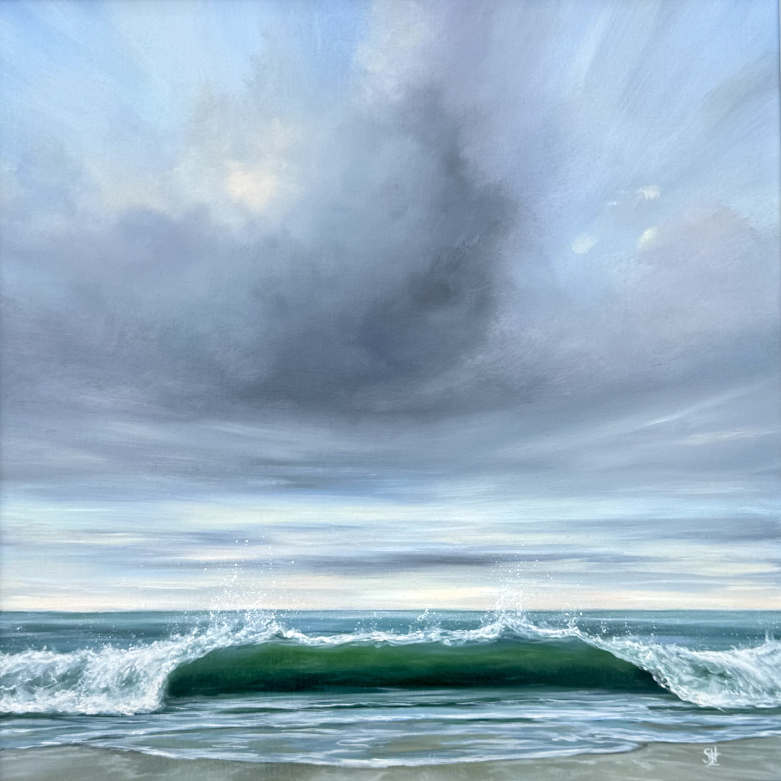 A scenic view of the ocean with waves crashing onto the shore and a sky with scattered clouds.