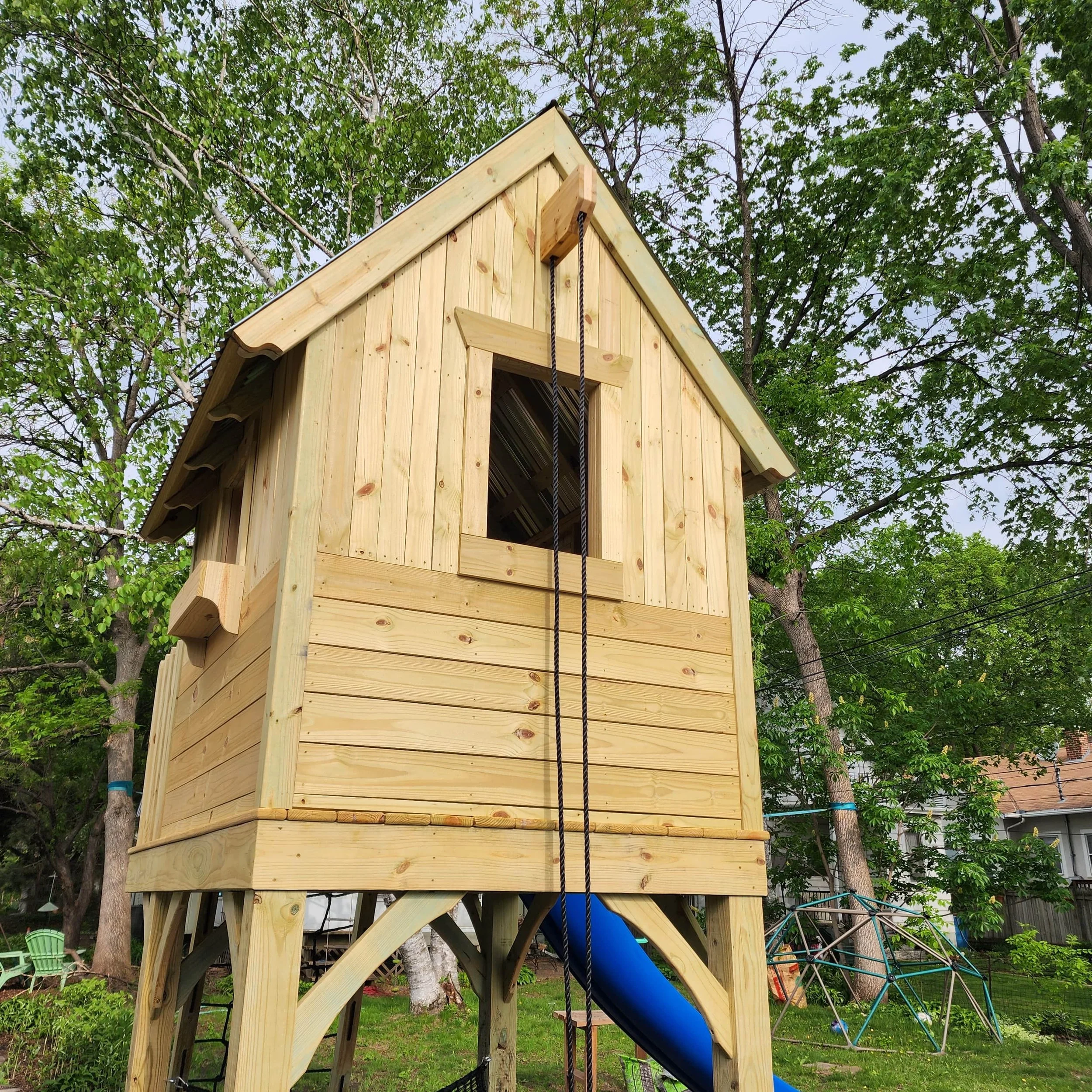 custom play structure made out of wood with a cottage style