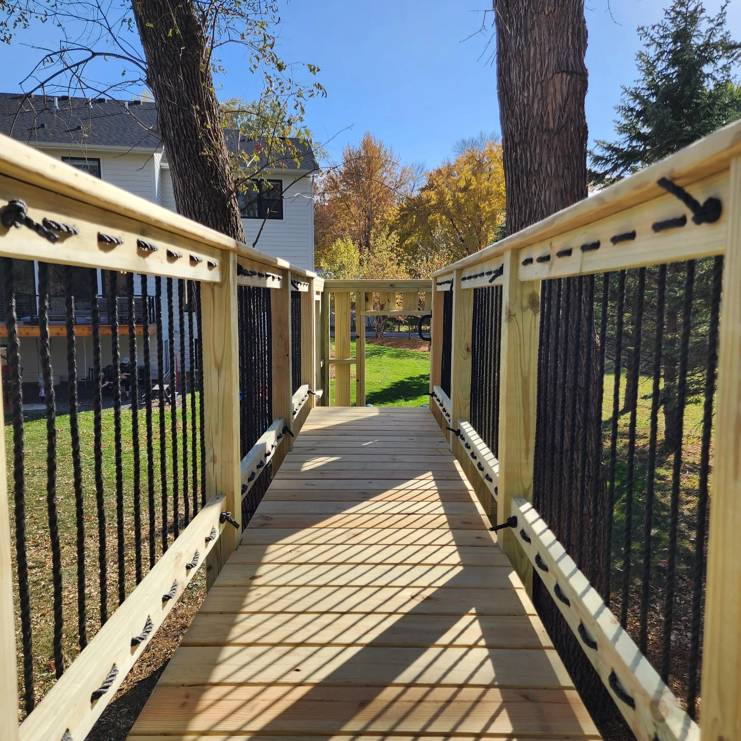 custom tree fort bridge with black rope railings