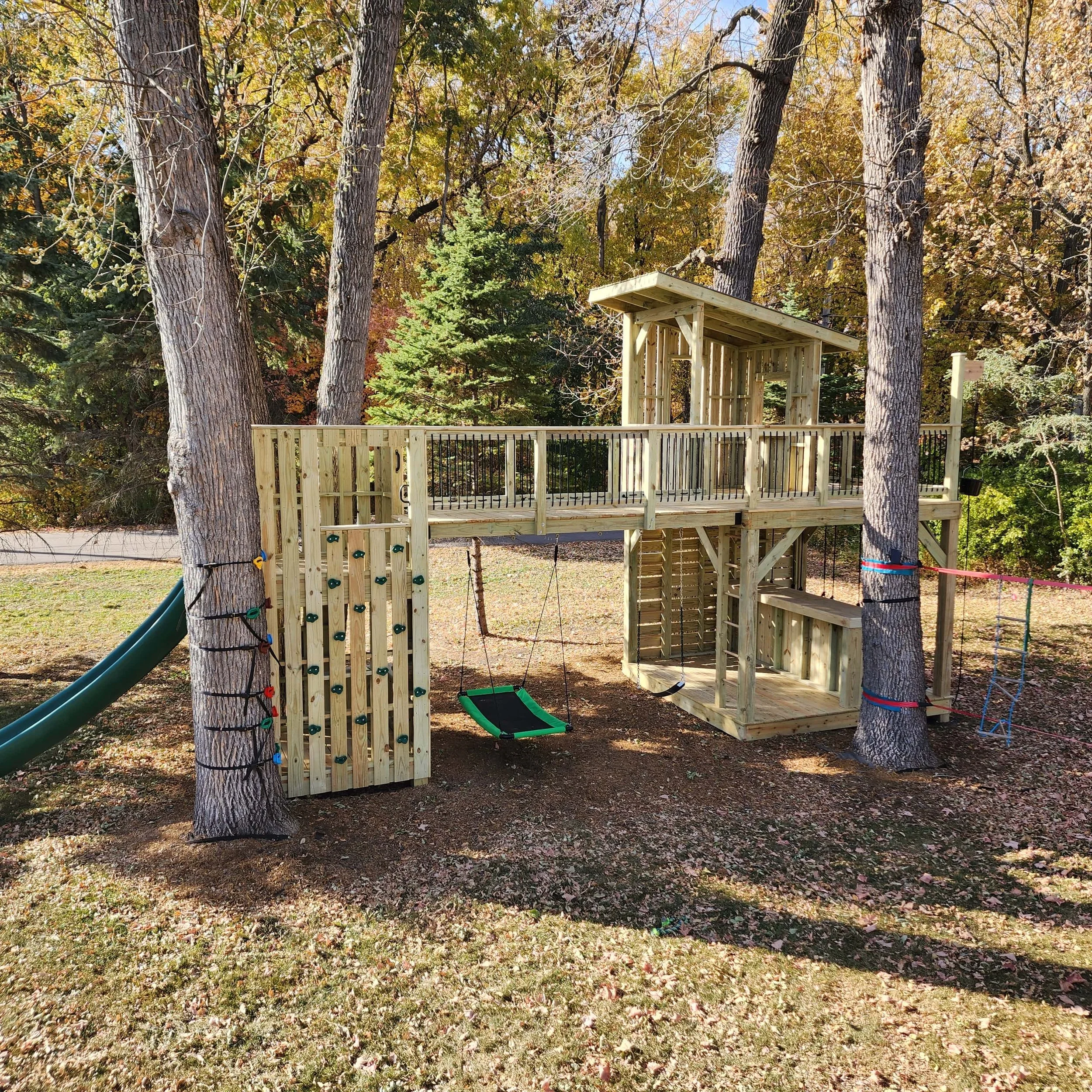 custom tree fort with climbing tower and bridge