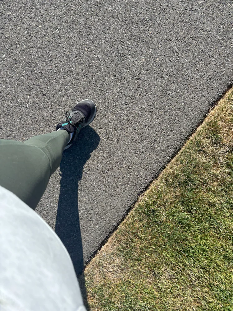 Looking down at sneakers walking along a path