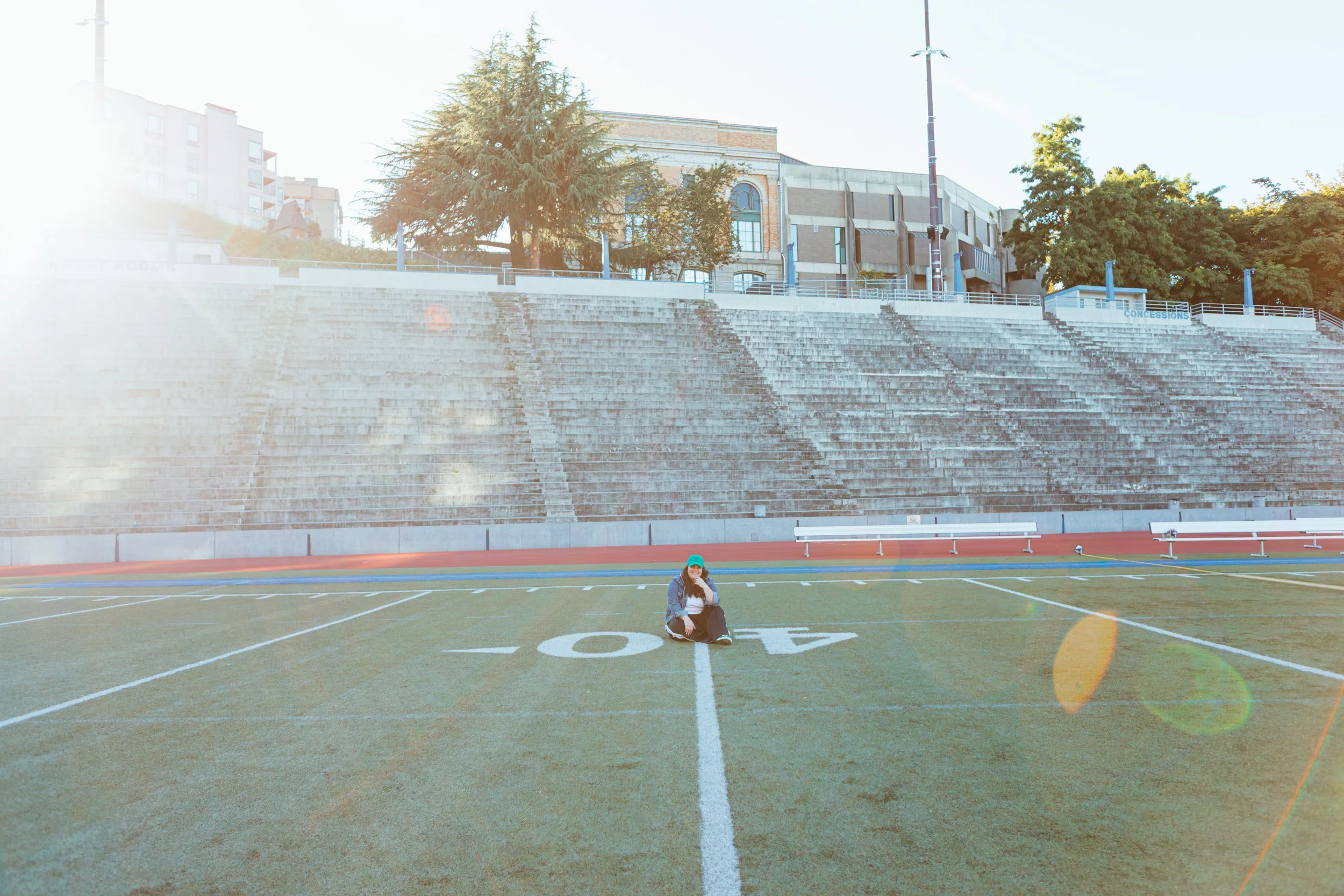 Ellyn sitting alone on the 40-yard line of an empty stadium
