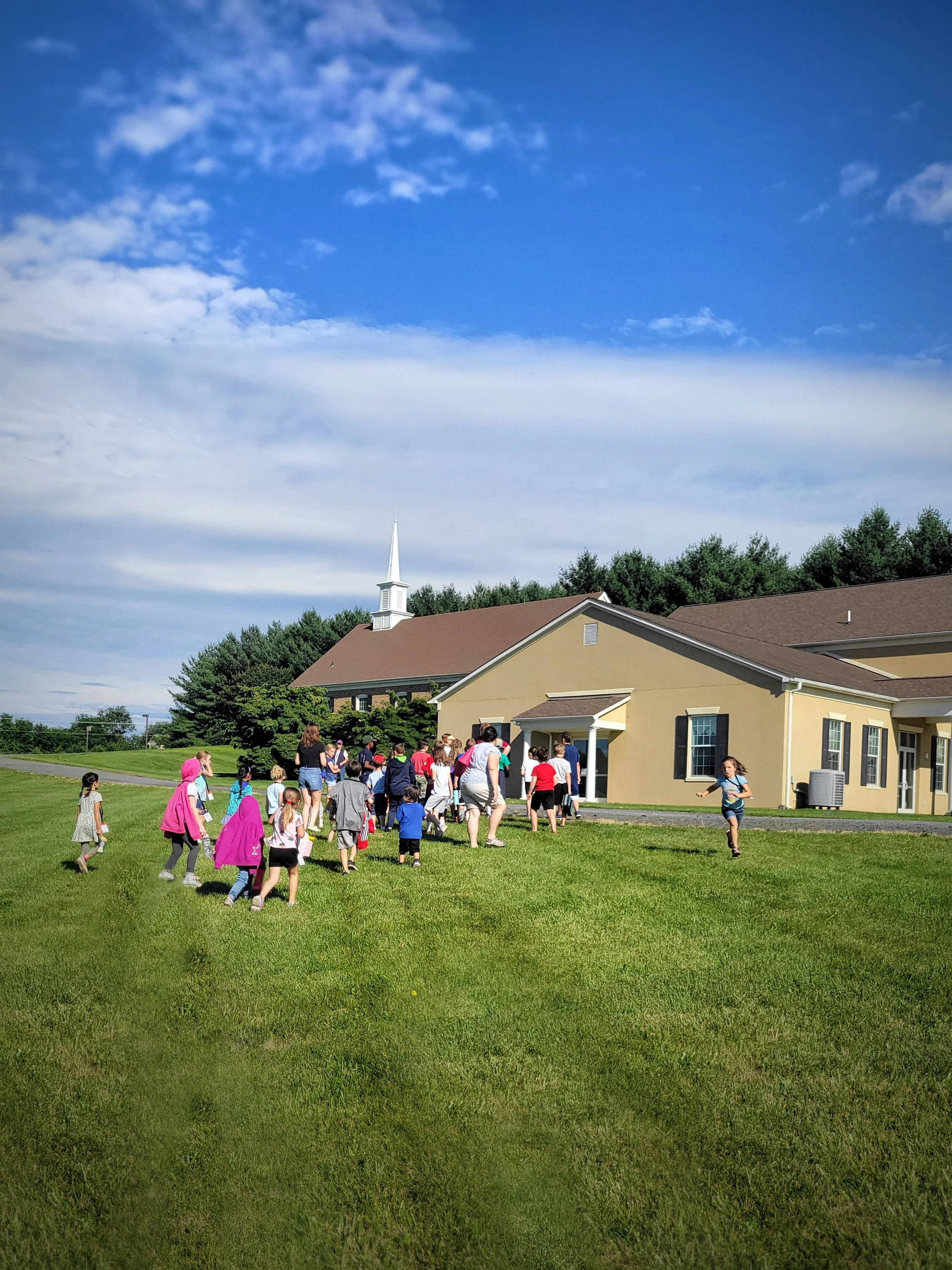 Children running across church lawn