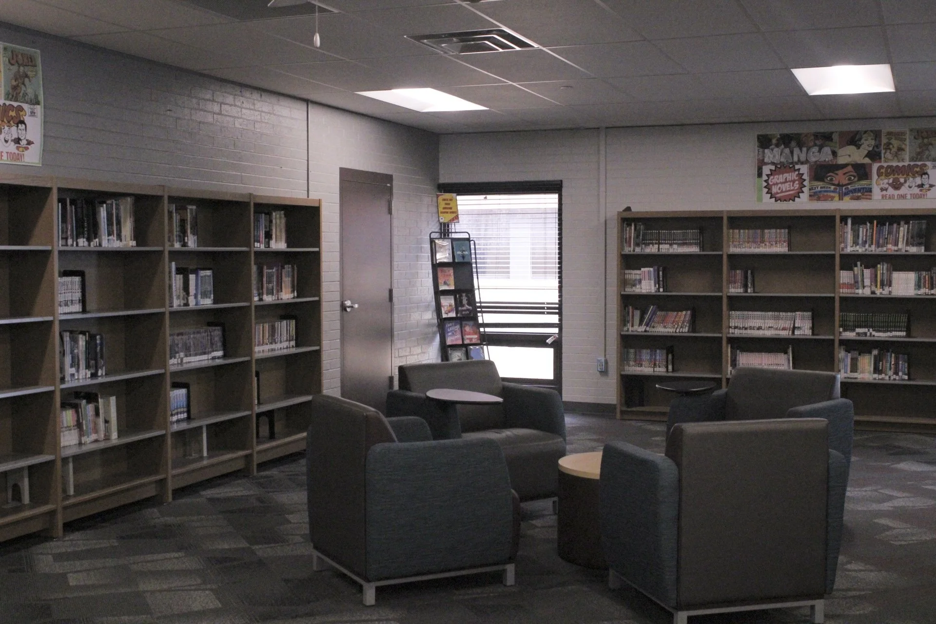 Four lounge chairs in the library sit around a table.