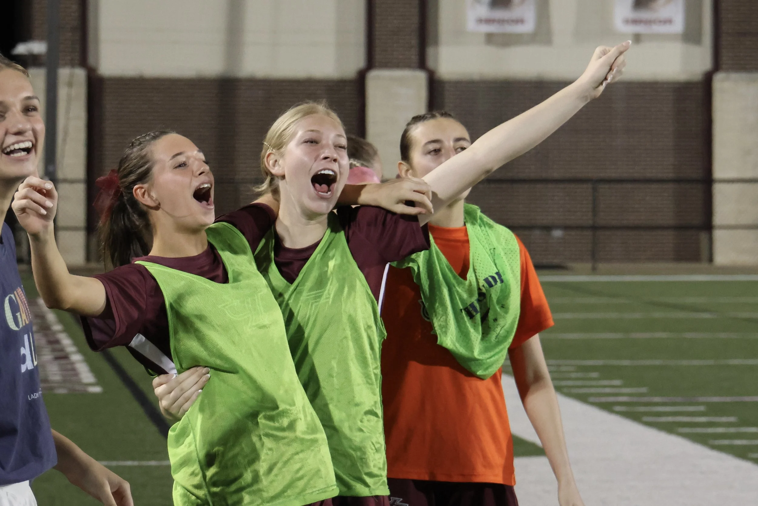 soccer girls hugging on sidelines.