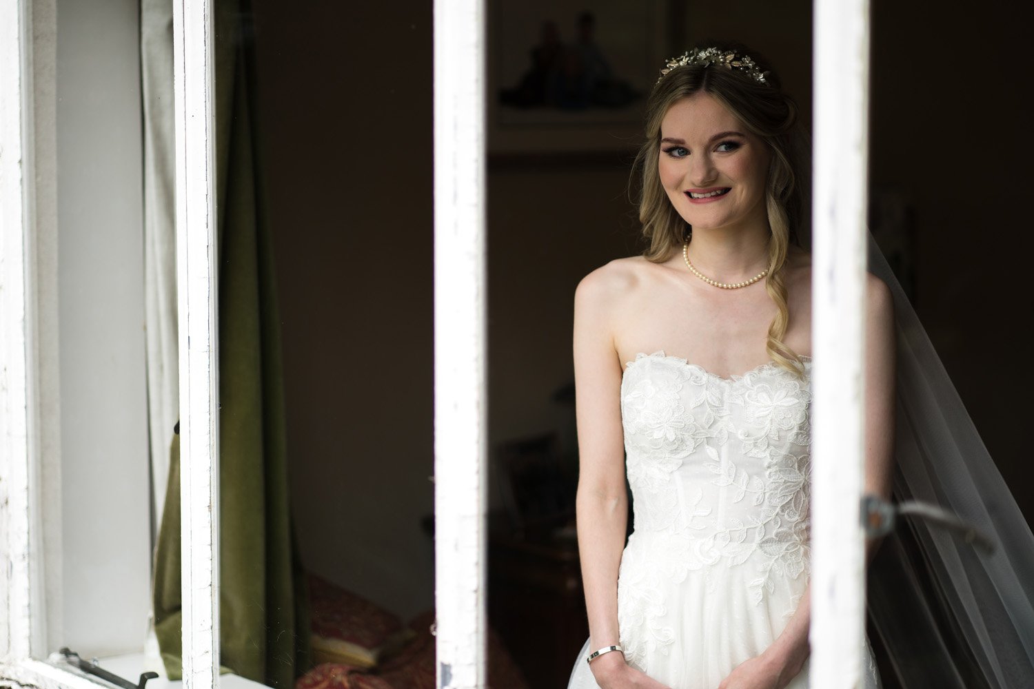 Bride in wedding dress looking through window in East Yorkshire (Copy) (Copy) (Copy)