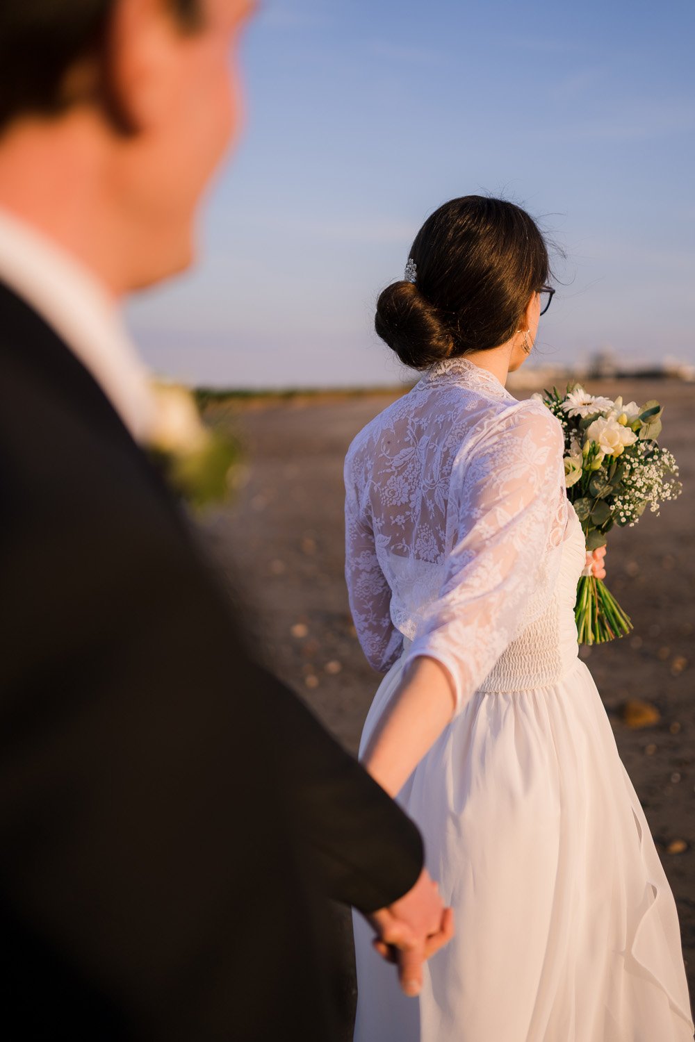 Bride and groom walking along Hornsea beach