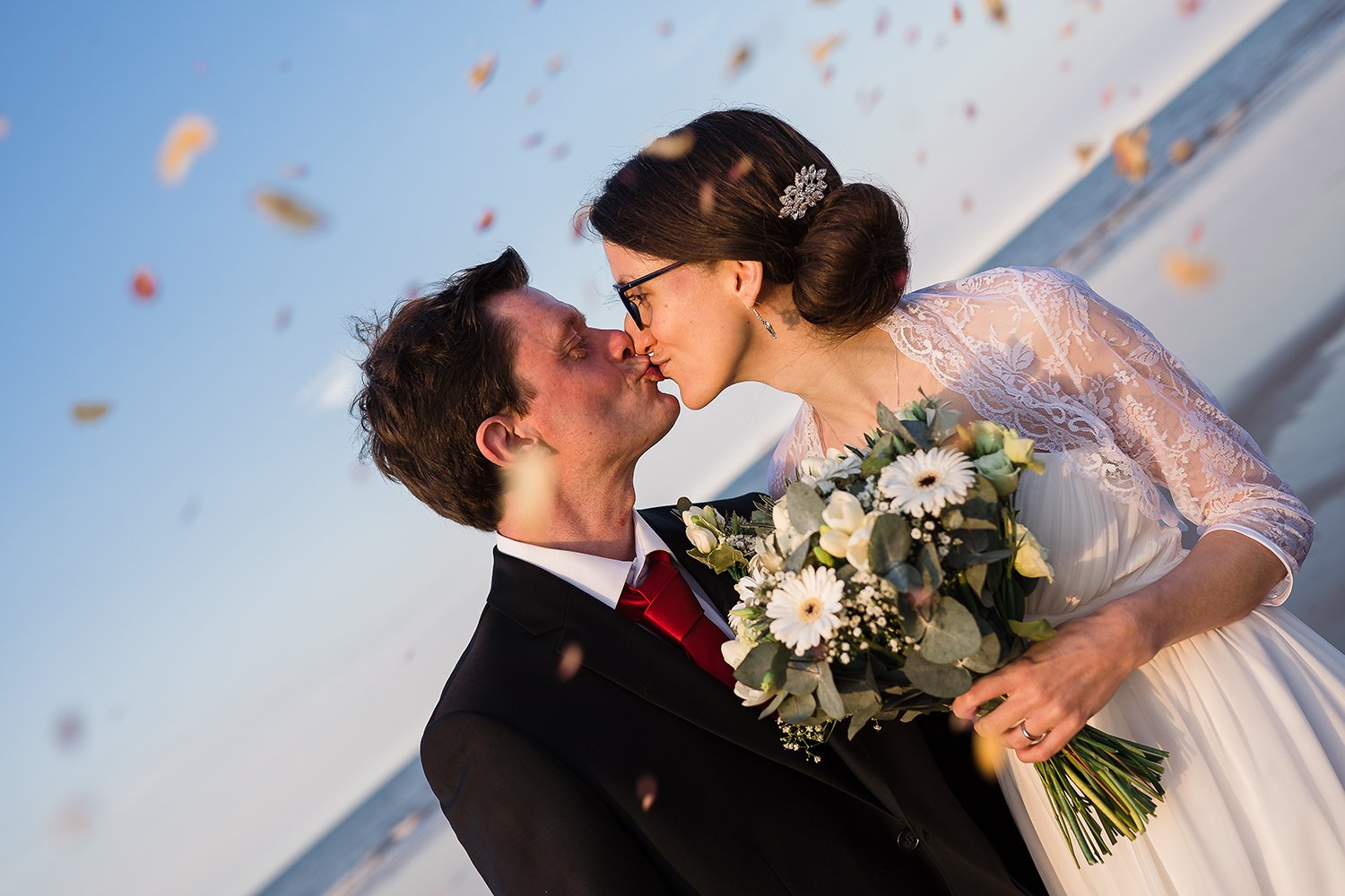 Bride and groom with natural rose petal confetti
