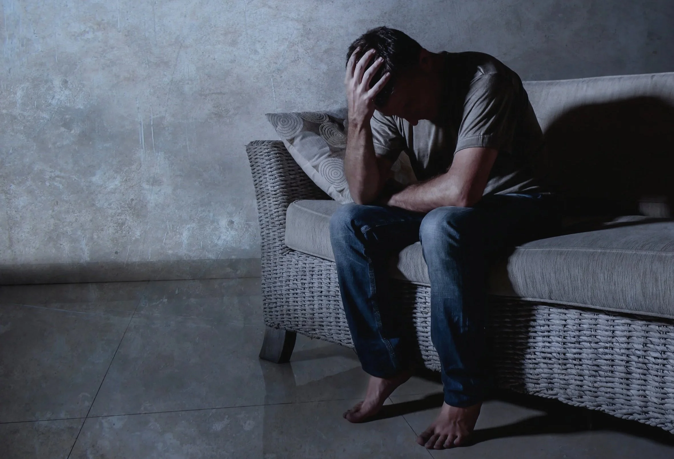 Grieving man slumped on couch.