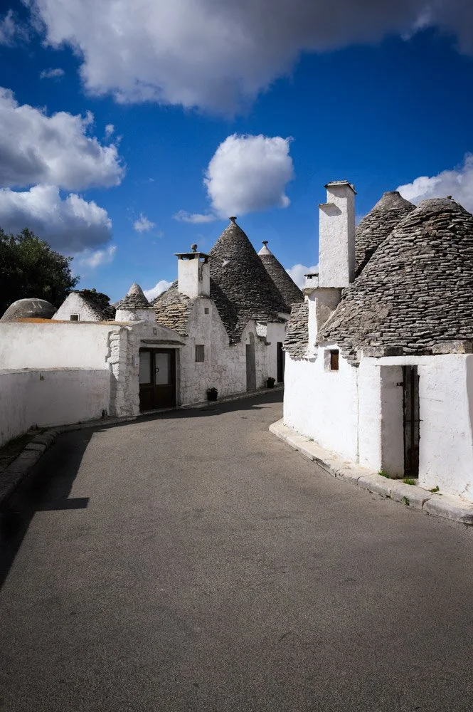 A quiet afternoon  in Alberobello, Italy.  The “truli,” whitewashed stone huts with their conical roofs, are distinctive to the Puglia region of southern Italy.