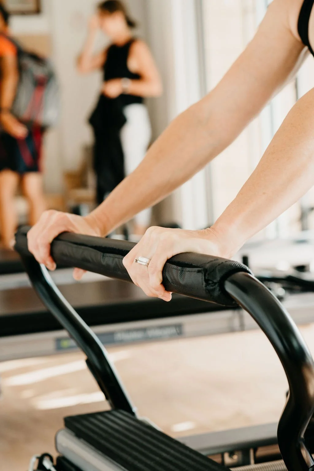 Close-up of hands and arms on reformer machine during strength and stability Pilates training