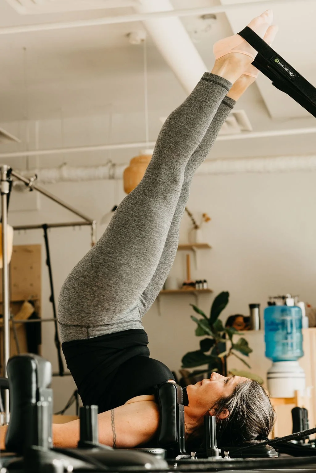 Woman doing leg raise exercise on a reformer machine to build core strength and stability