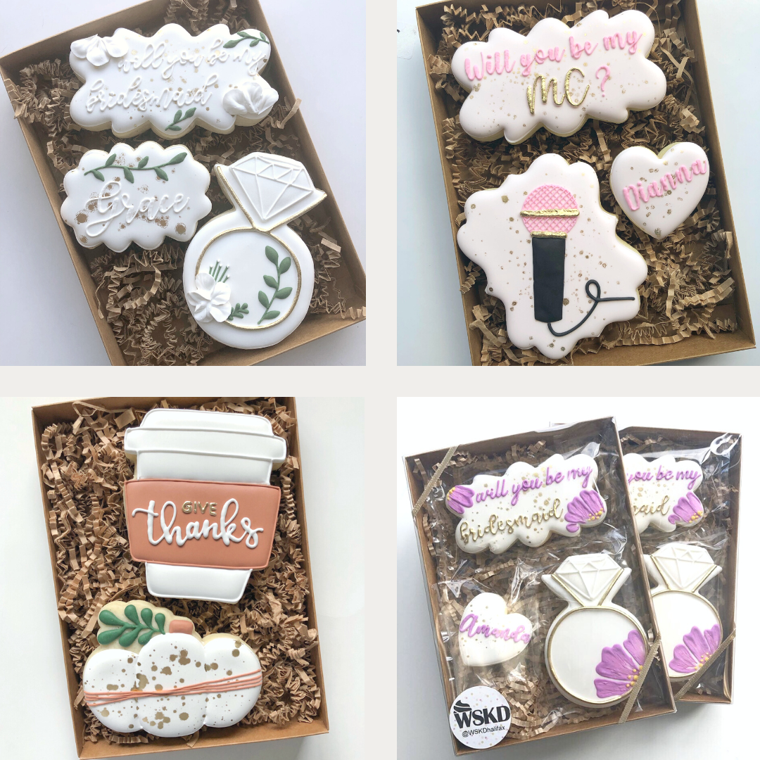 Collection of custom decorated cookies in gift boxes, including designs that say 'will you be my MC,' 'thanks,' and 'will you be my bridesmaid,' diamond shaped cookies, a ring, a pumpkin, a microphone, and flowers.