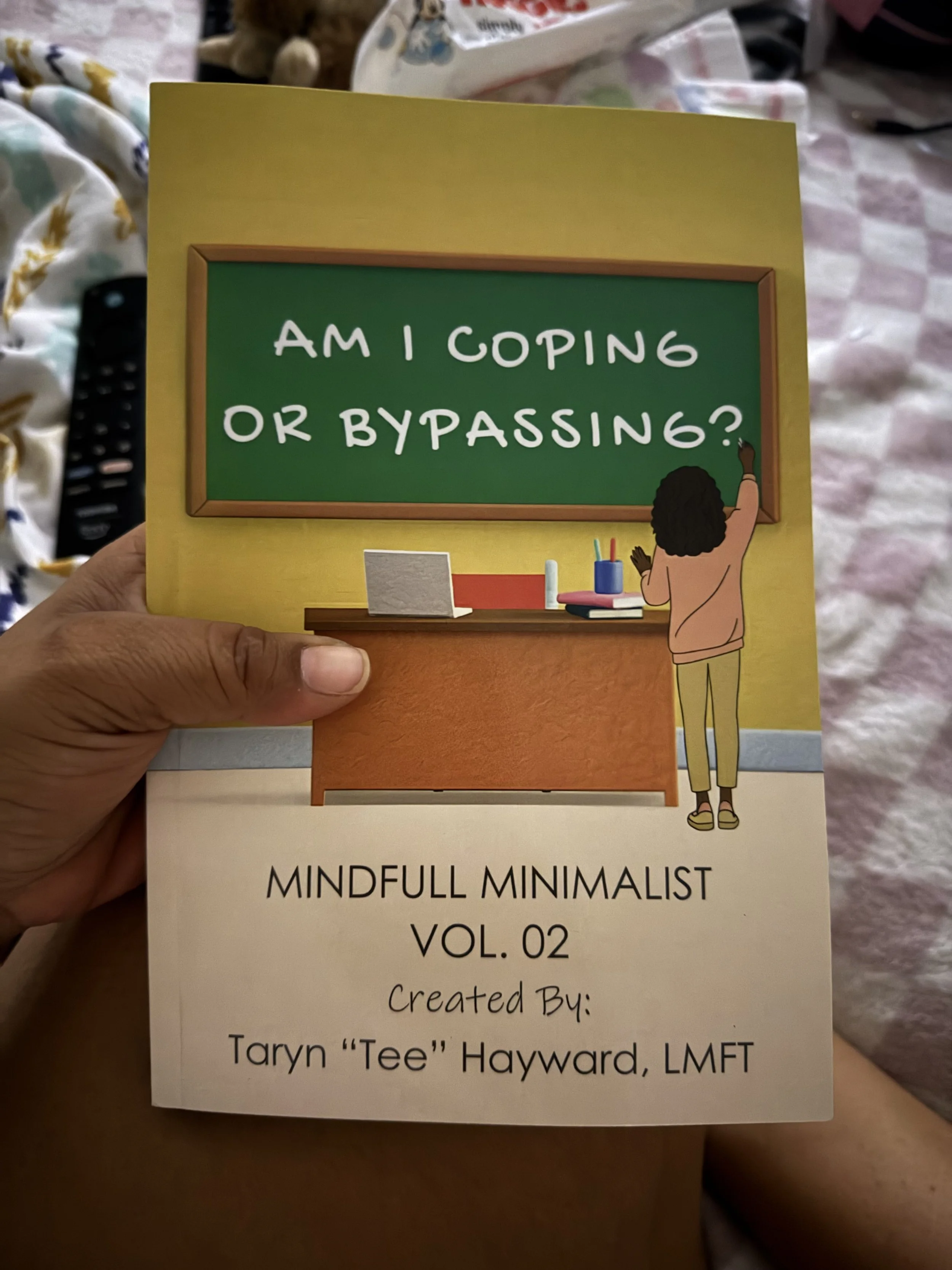 Reader holding their copy of “Am I Coping or Bypassing? MindFull Minimalist Vol. 2,” a mental health and emotional wellness workbook.