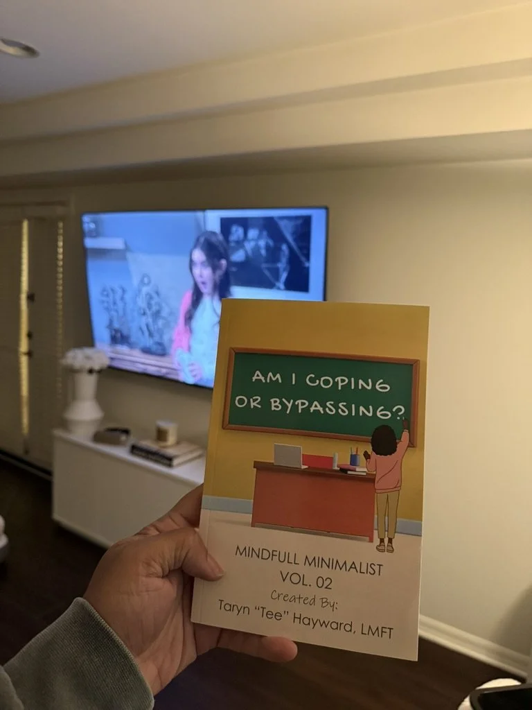 Supporter holding a copy of “Am I Coping or Bypassing? MindFull Minimalist Vol. 2” by therapist and author Taryn “Tee” Hayward.