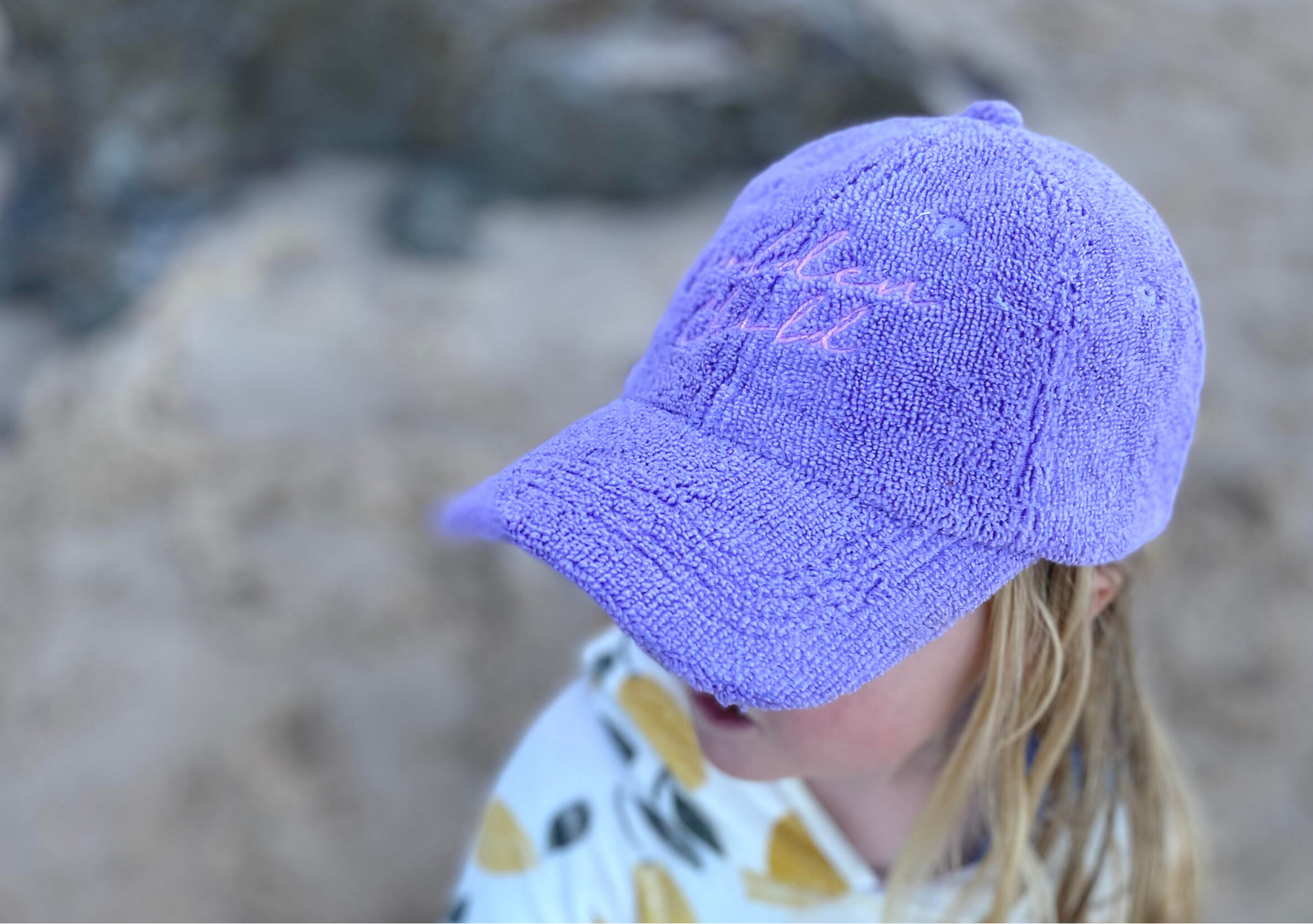 a girl wearing ca terry towelling cap in lilac colour