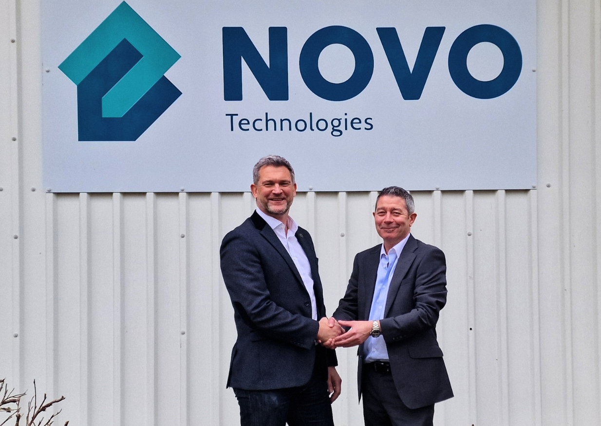 Executives from VINCI Energies and Novo Technologies shake hands outside Novo Technologies headquarters following acquisition announcement.