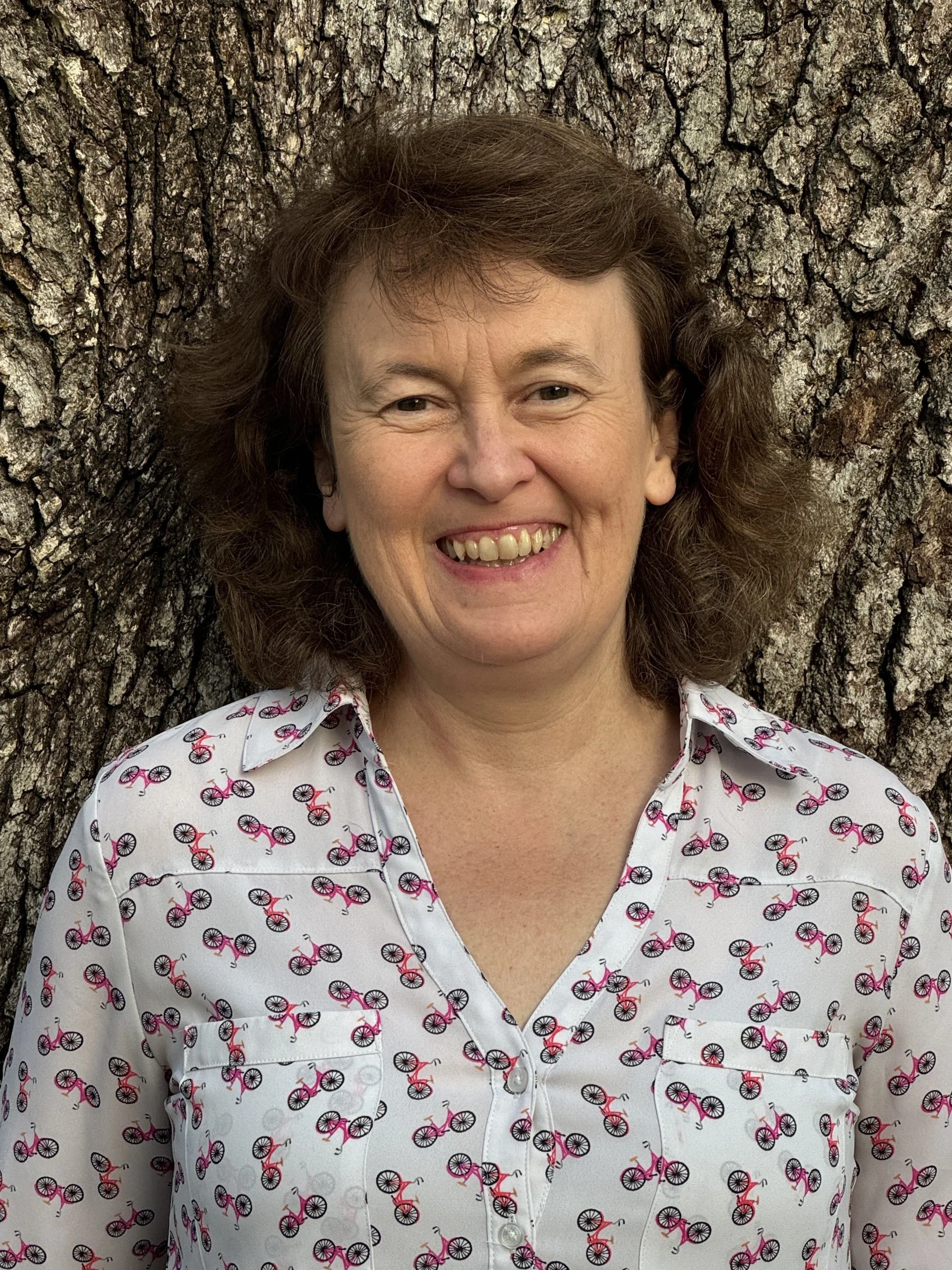 Professional headshot of Lisa Spiro with short brown hair standing against a tree