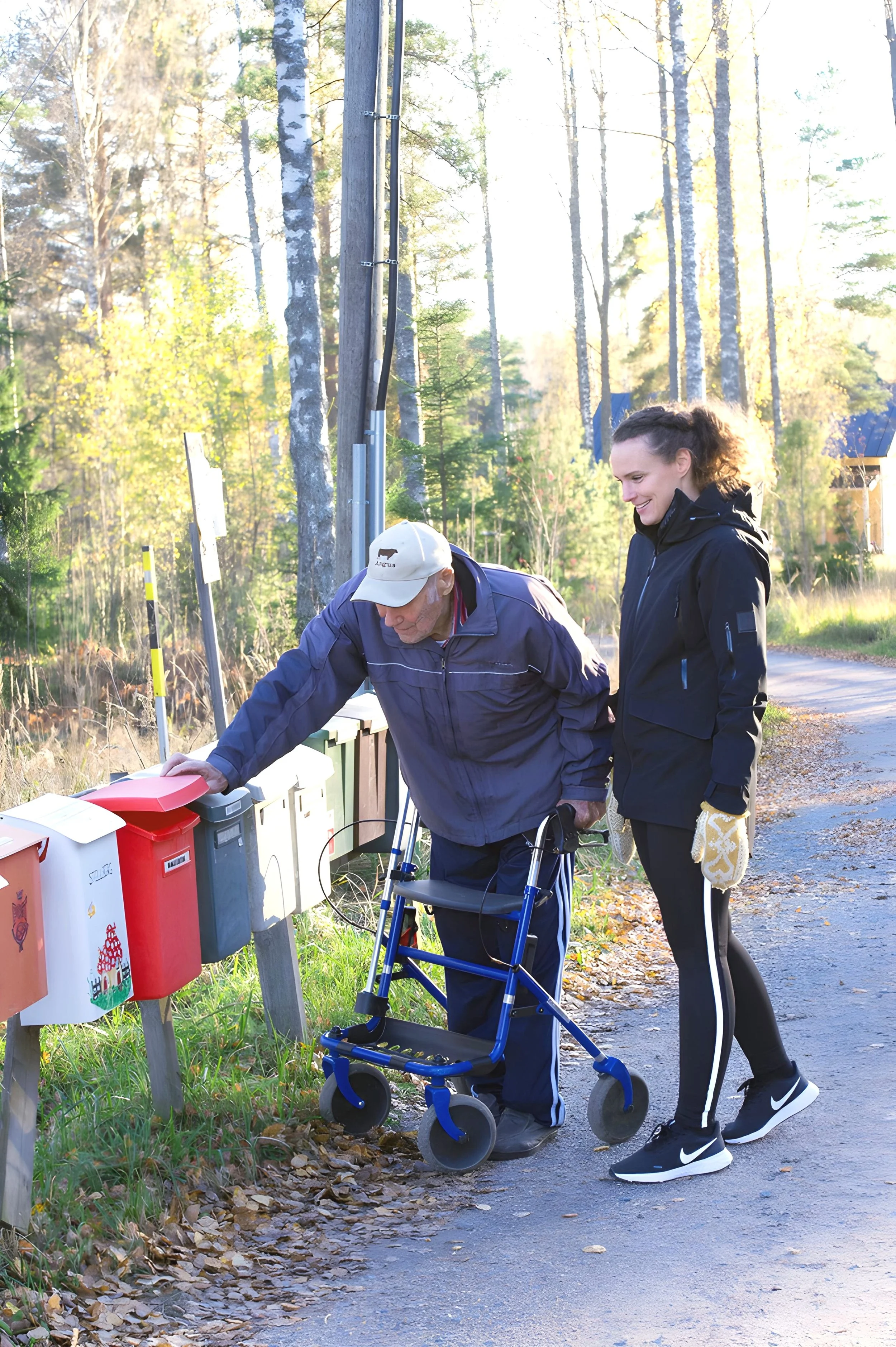 Henkilö tarjoamassa apua ikäihmiselle arjen toiminnoissa pihalla.