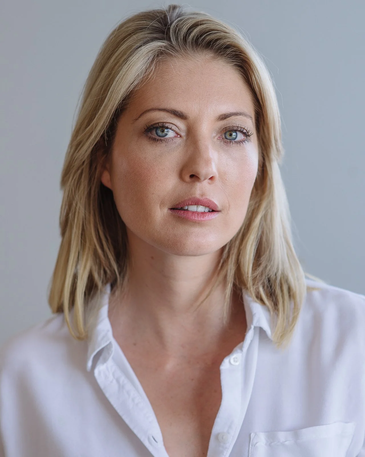 Modern business portrait and acting headshot of a woman against a light grey background in Cape Town.