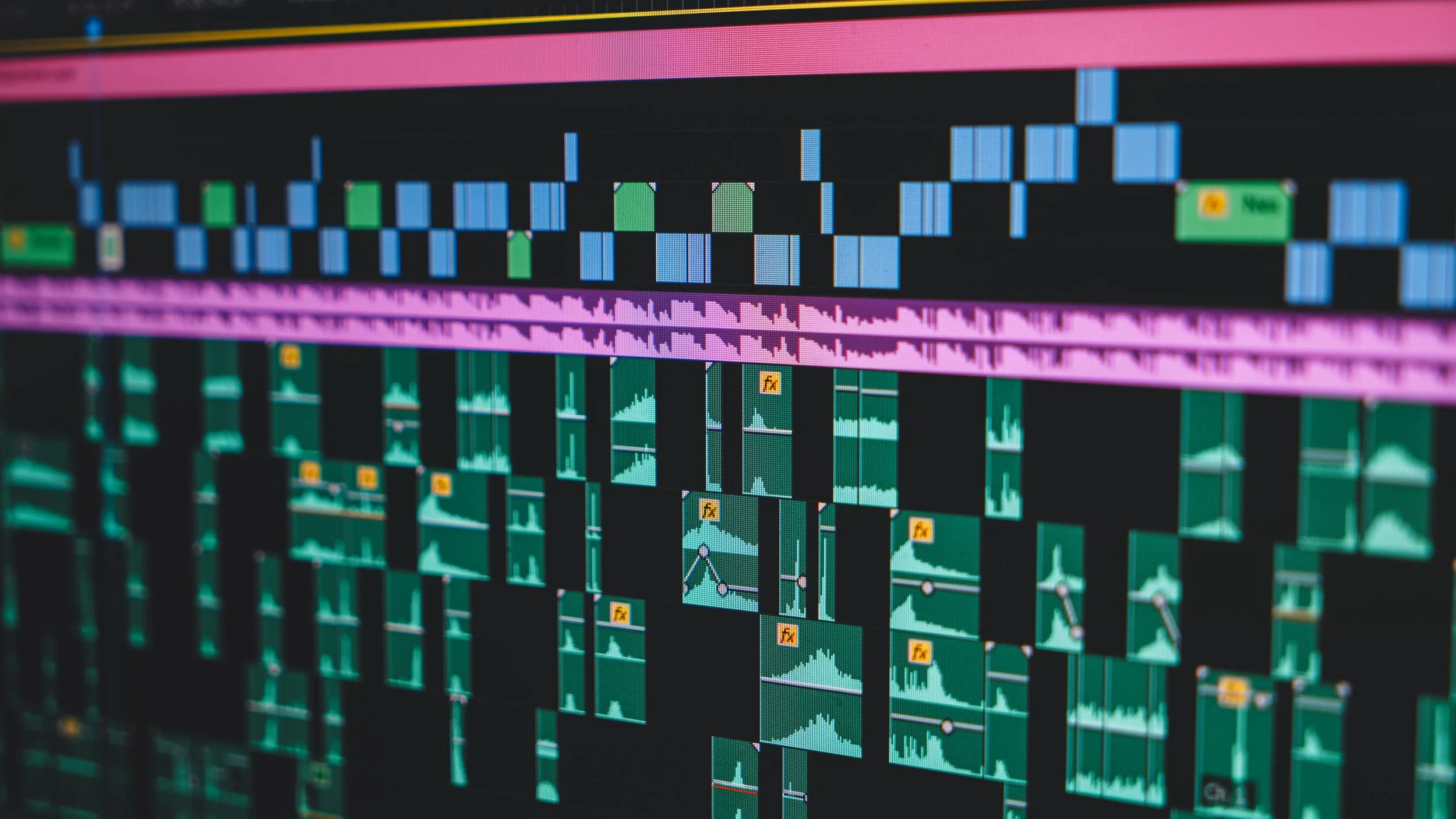 Close-up of a computer screen displaying a digital music editing software with waveforms, timelines, and various editing tools.