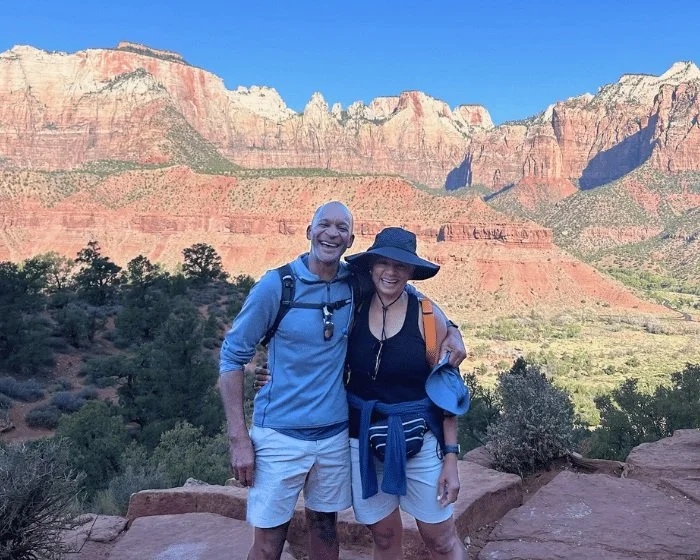 A couple smiles while hiking in zion national park