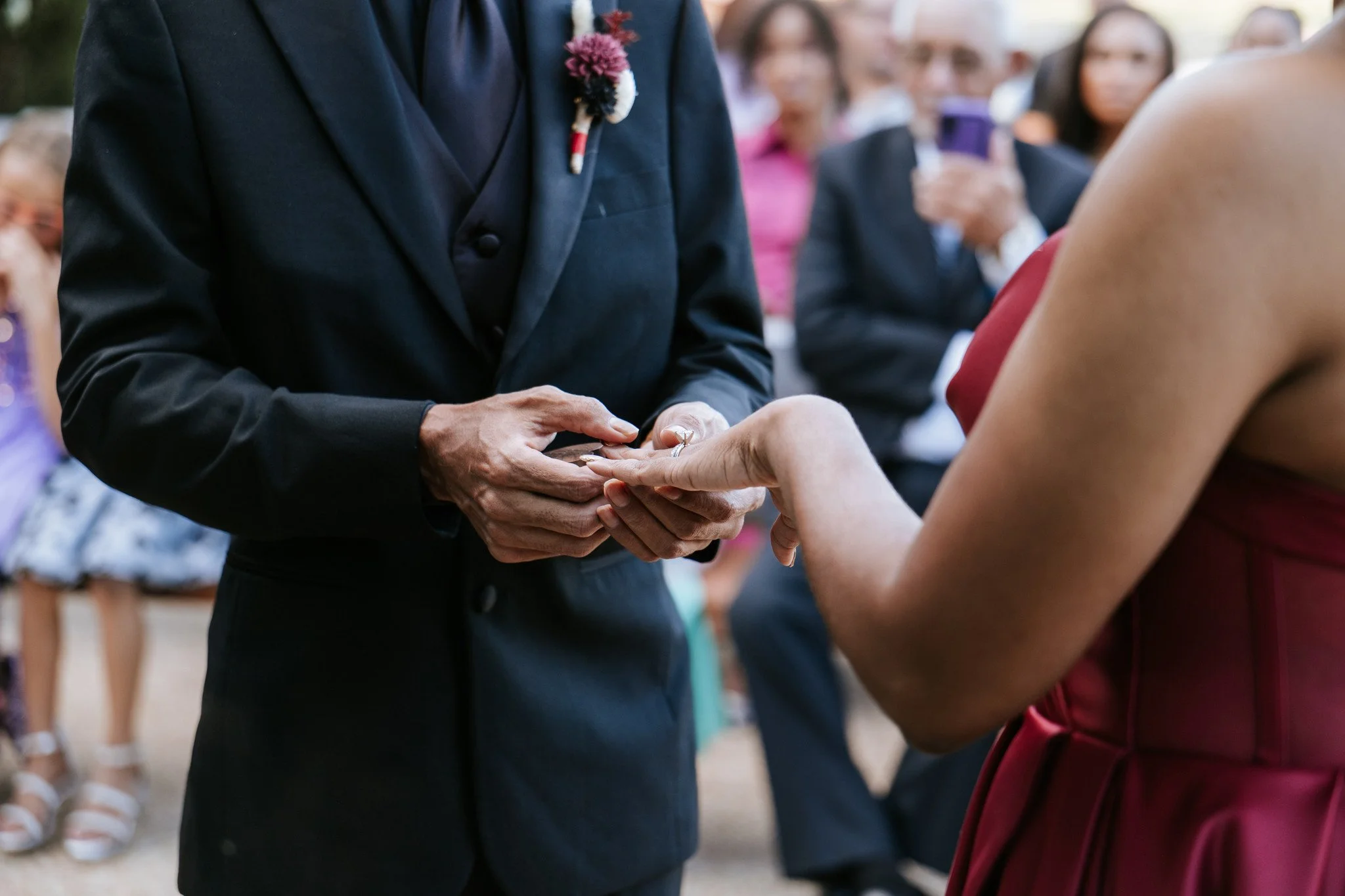Groom puts the bride's ring on in the exchanging of rings, during their wedding reception