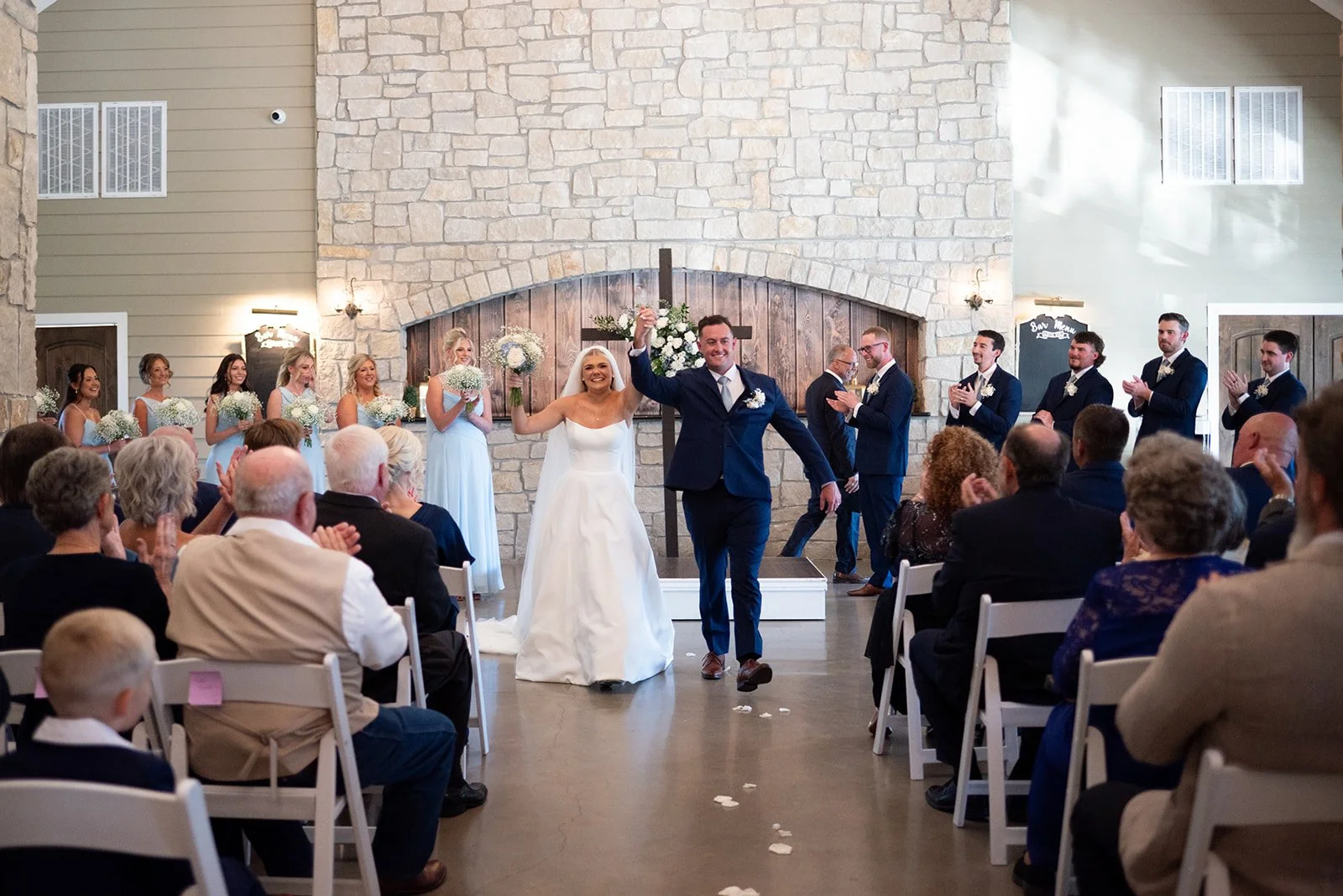 Cameron and Makenzie taking their first walk down the aisle together as newlyweds at their indoor venue.