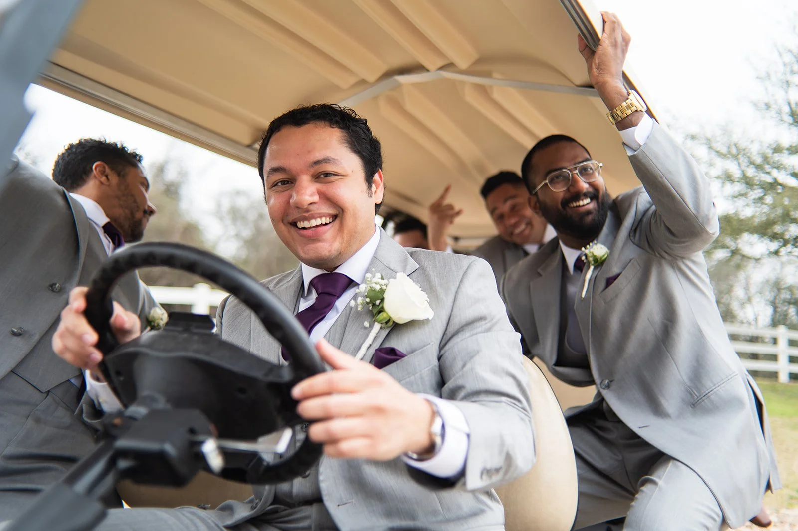Groom and groomsmen drive a golf cart around Inn at Quarry Ridge
