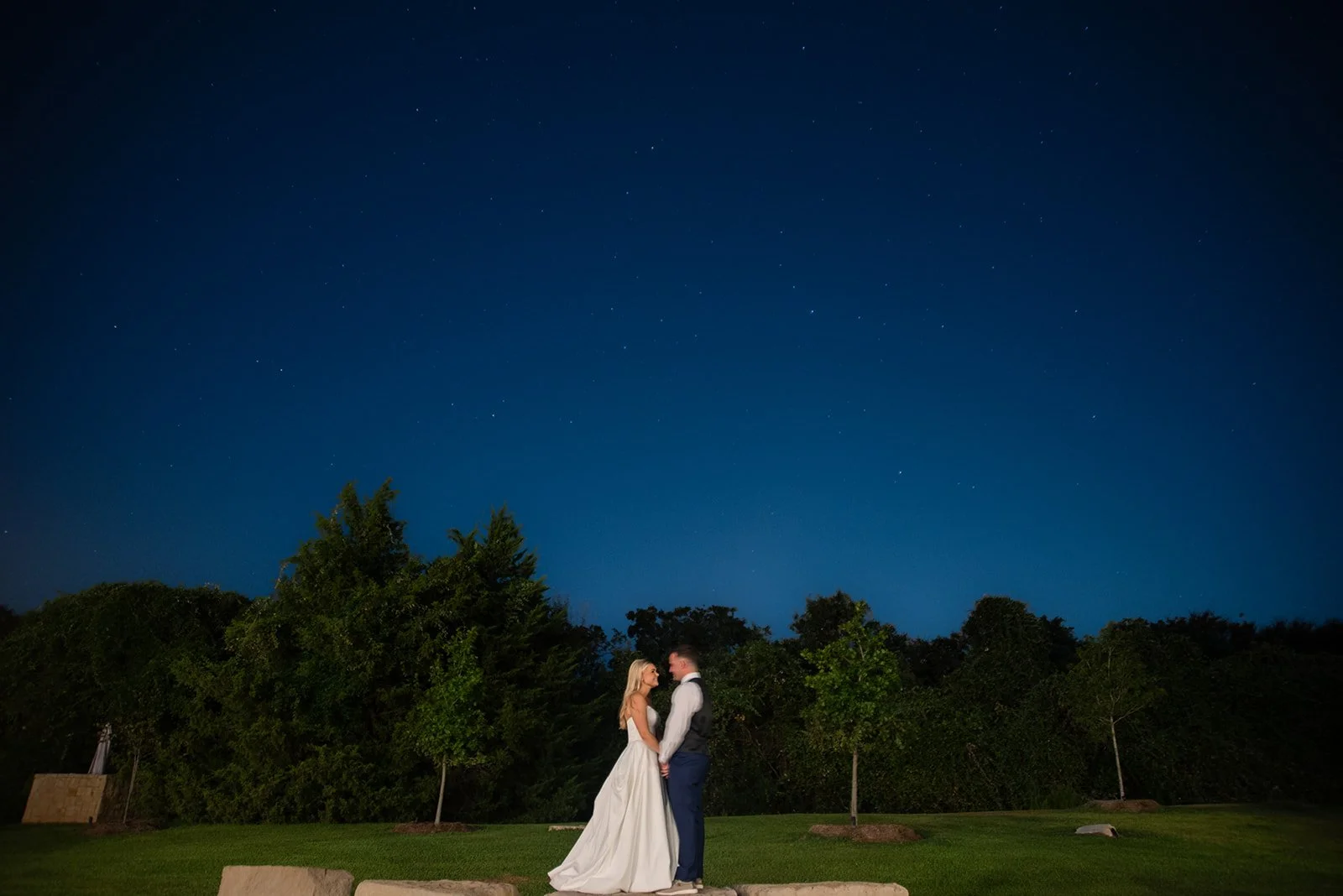 Bride and groom share a romantic moment under the open night sky