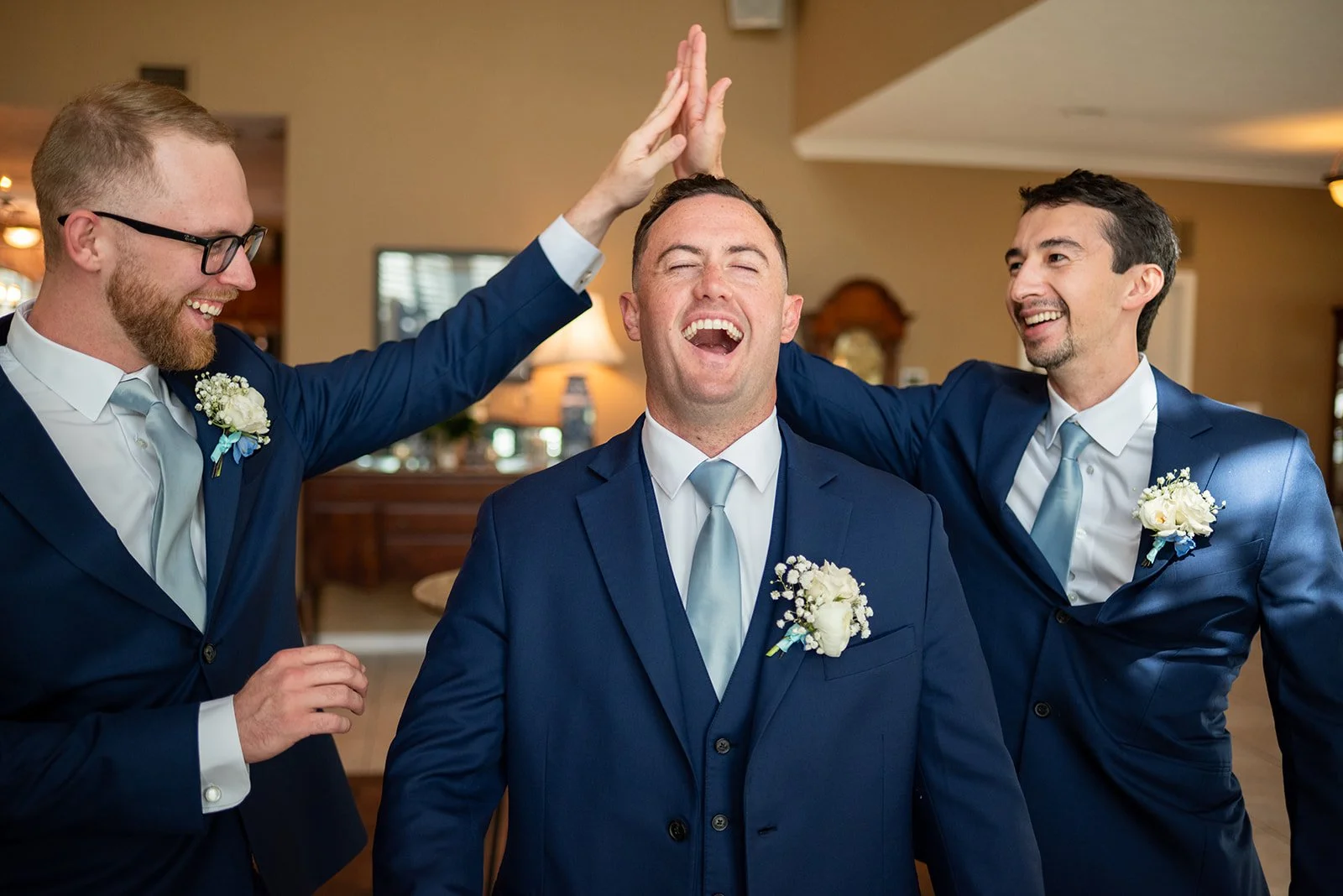 Cameron laughing with his groomsmen during the wedding celebration.