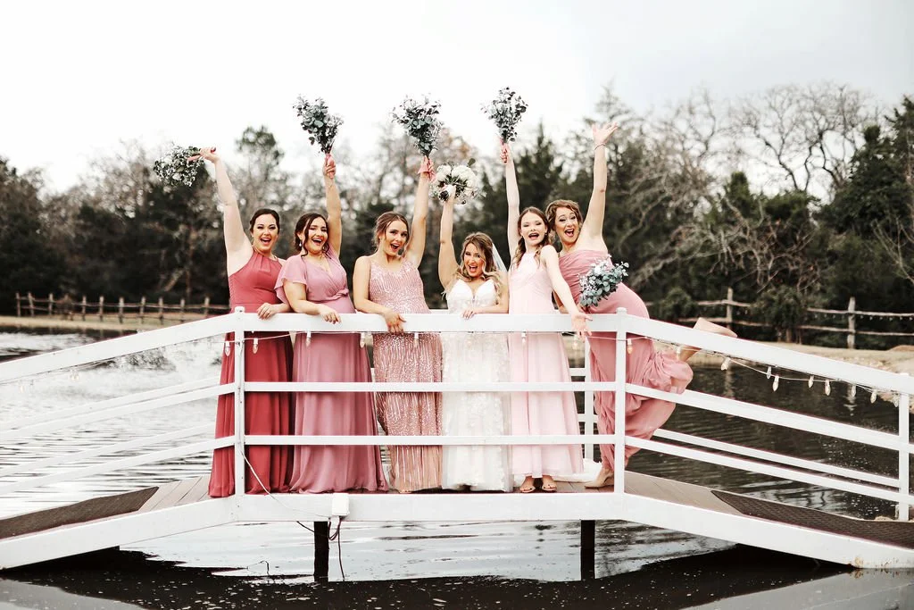 Bride and bridal party celebrate waterside on the bridge at Inn at Quarry Ridge