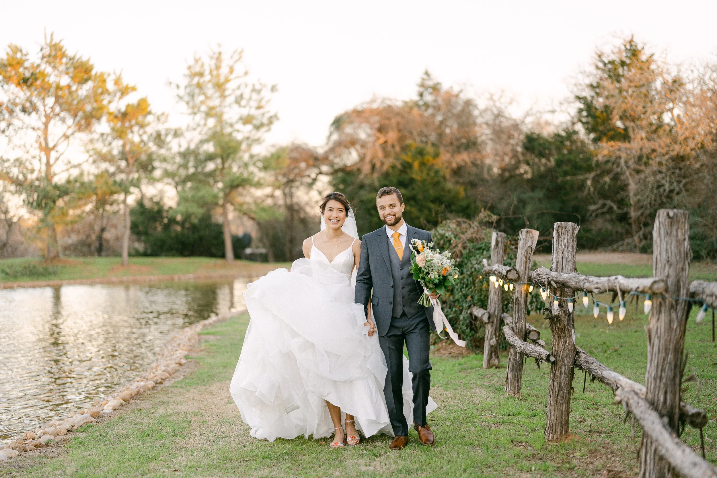 Bride and groom walk together around the lake and scenic outdoor grounds at Inn at Quarry Ridge