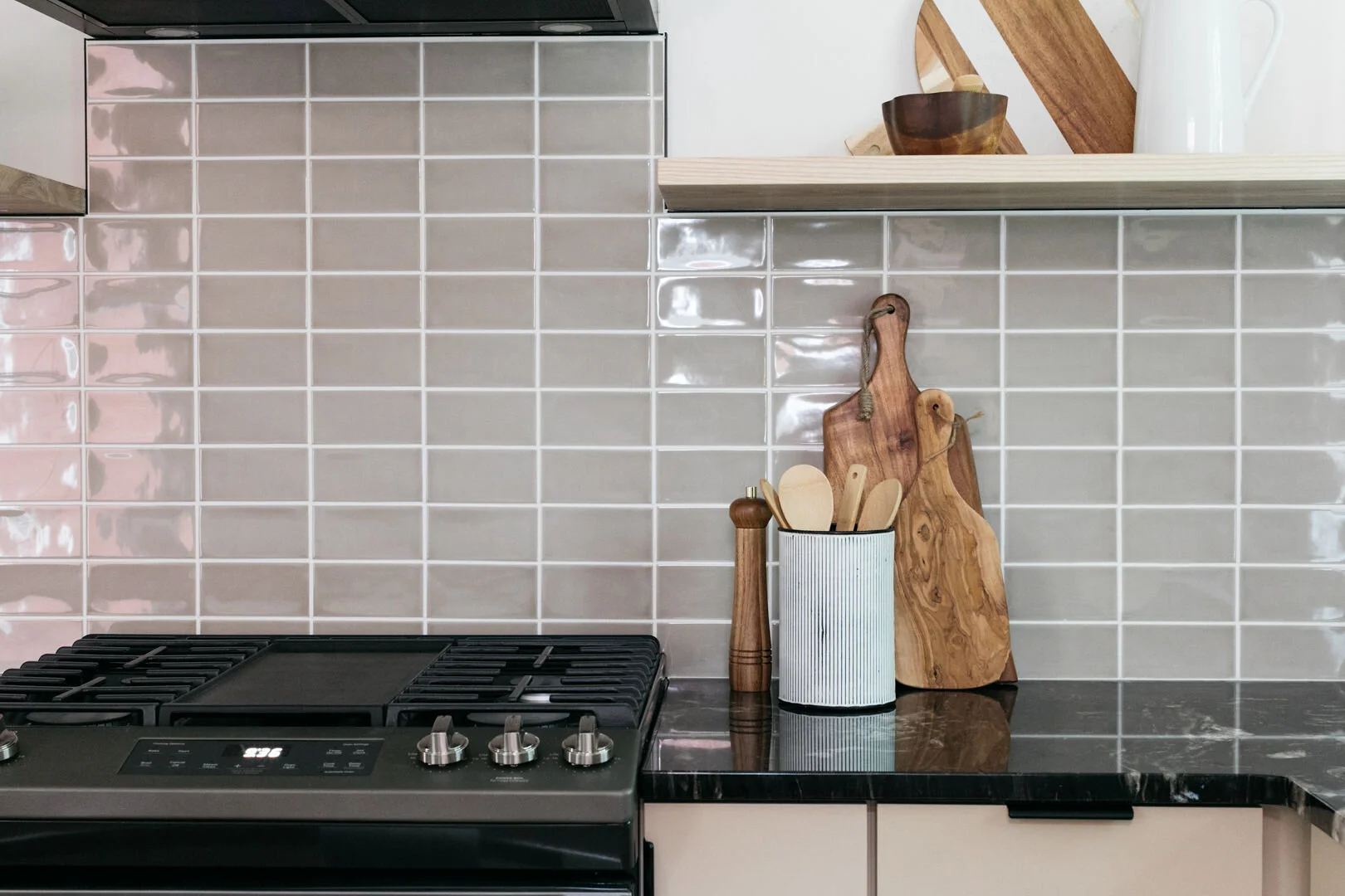 Modern kitchen with black granite waterfall island and Scandinavian-inspired cabinetry in the Nevin St. project.