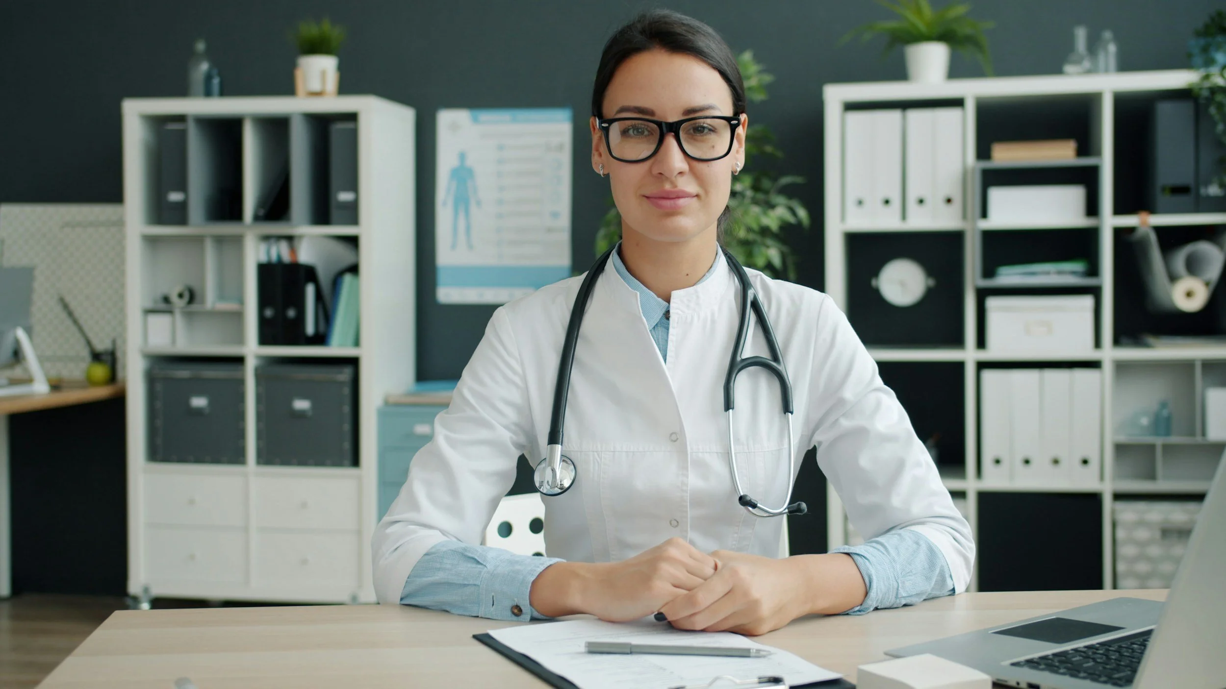 Physician with a stethoscope at her desk in a clinic office