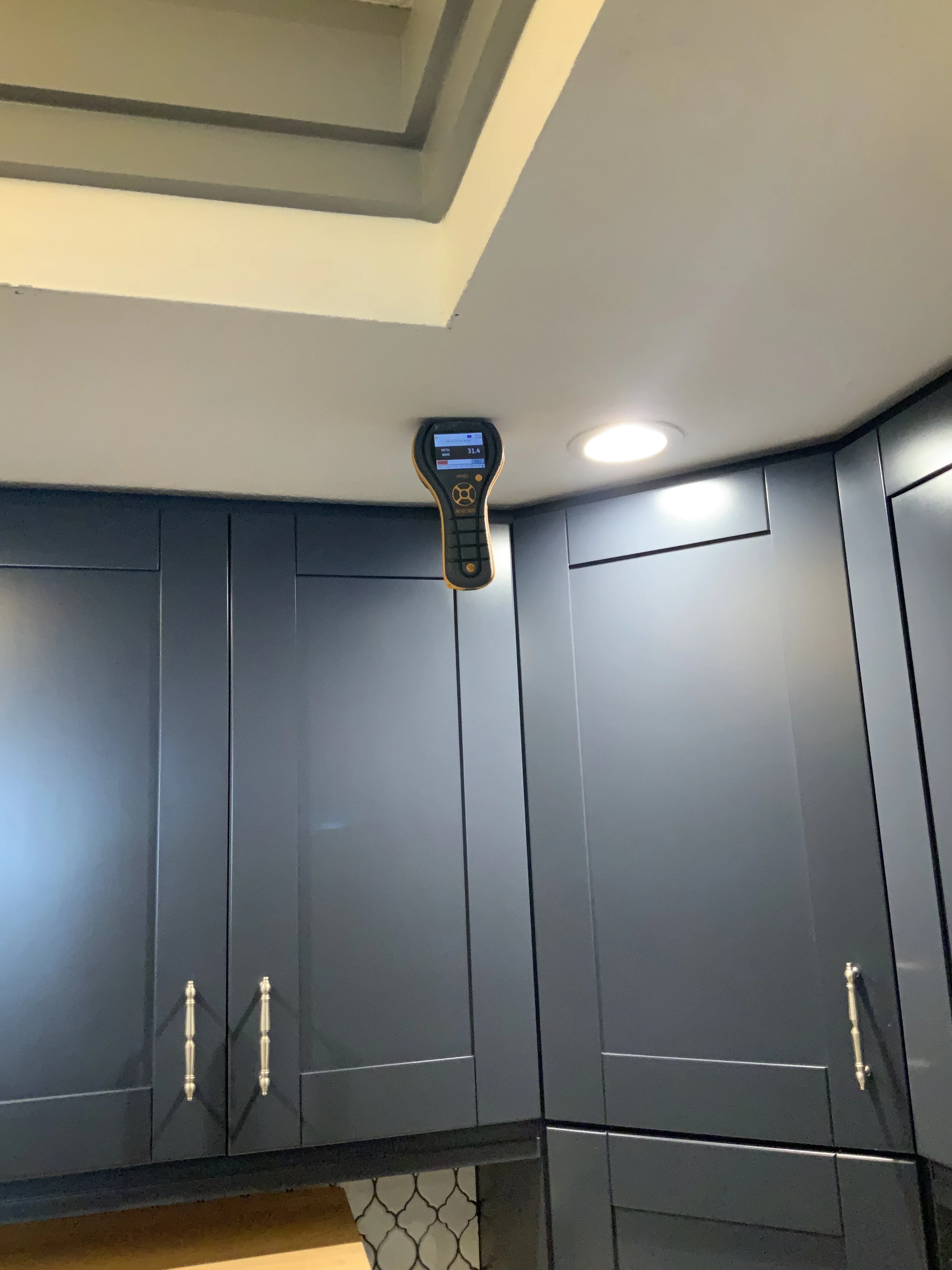 Moisture meter placed into a drywall ceiling checking for water intrusion, during a mold inspection