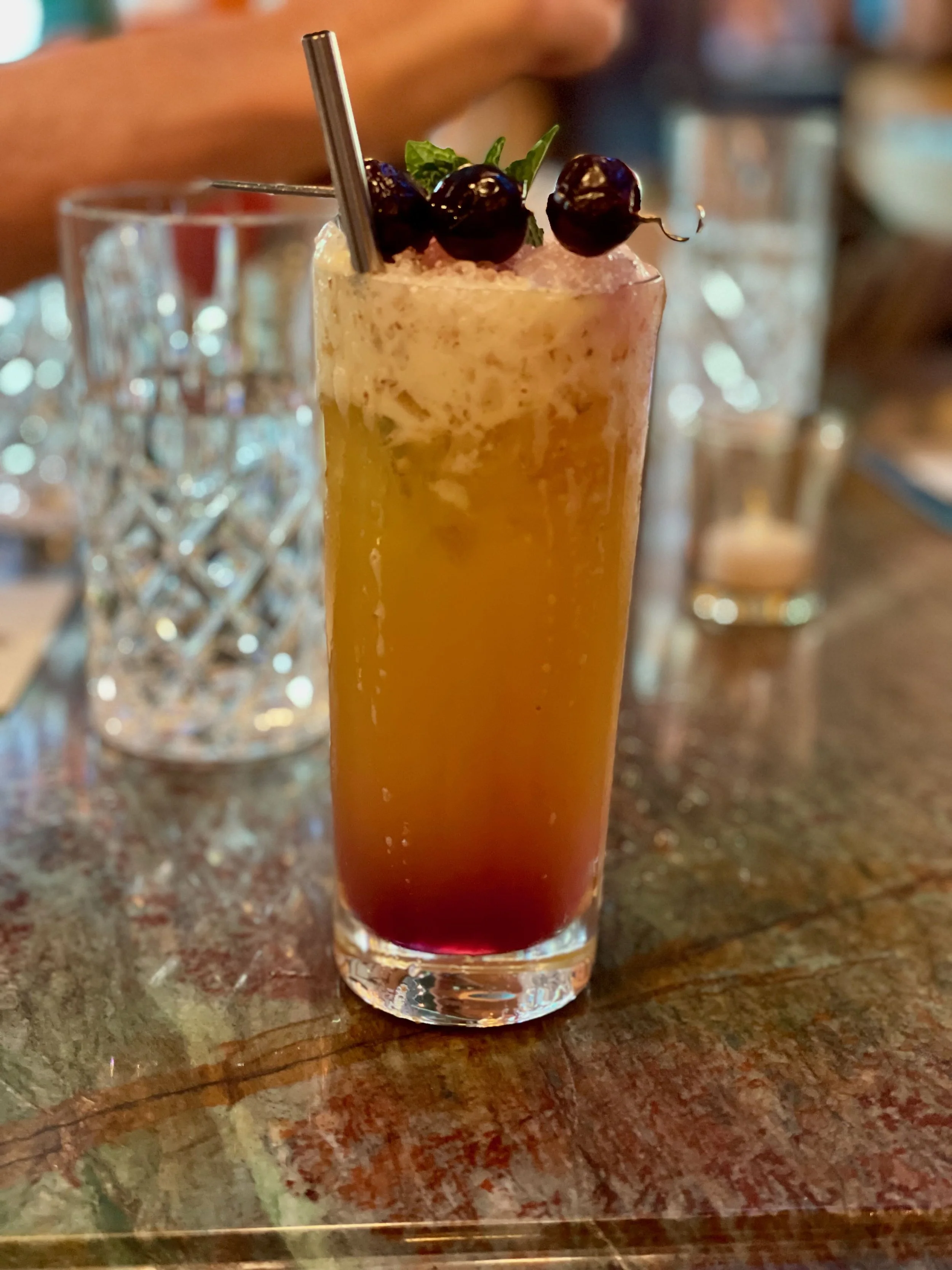 A cocktail drink with cherries on top.