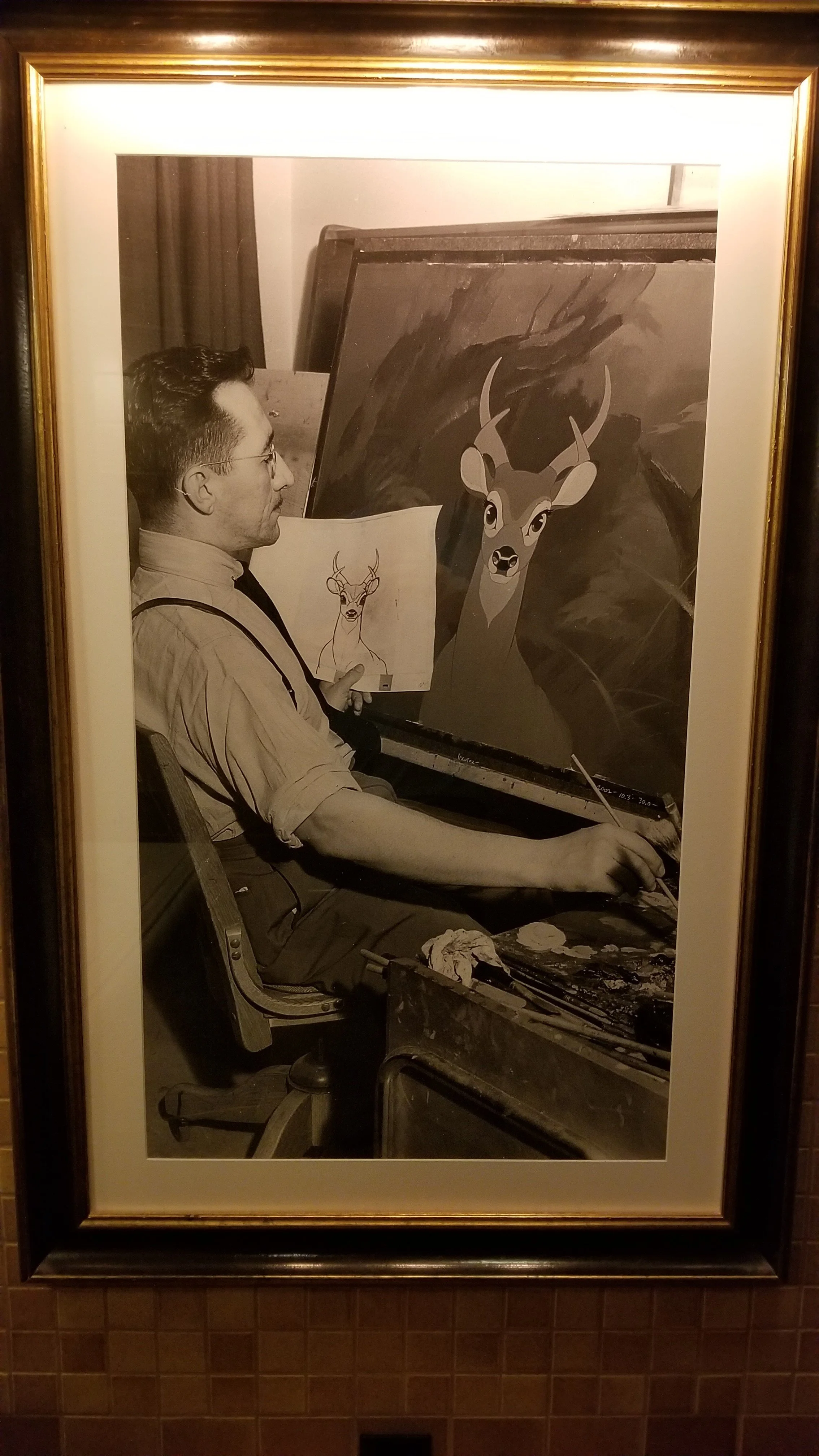 Photo with a man sketching a deer.