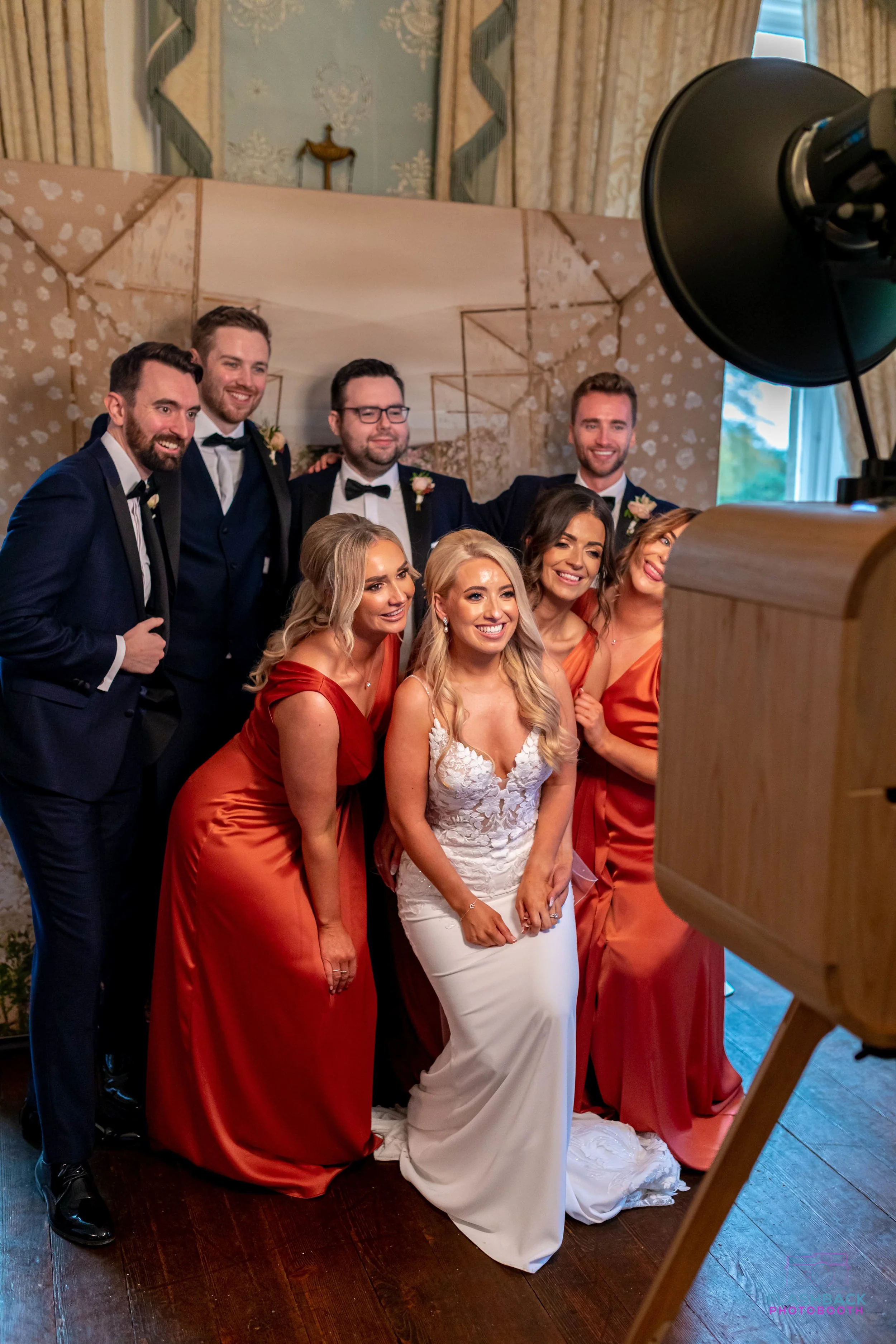 Bridal party takes a photo booth picture with bride and grom