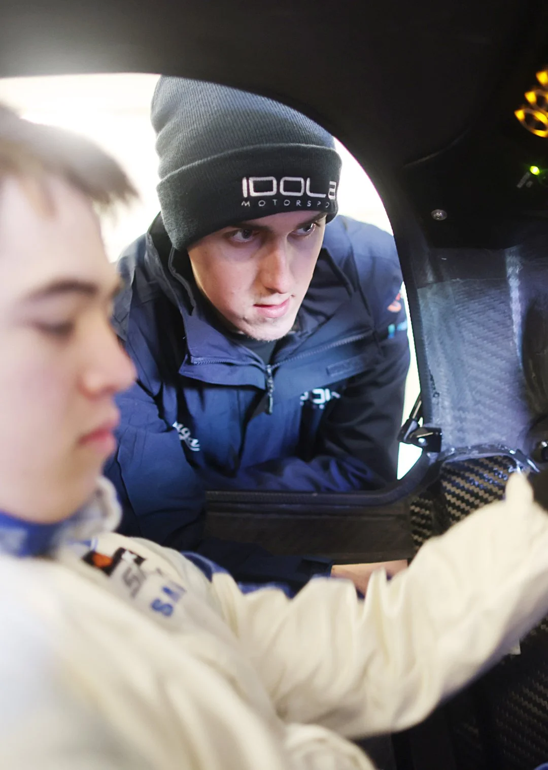 Jack Fabby talking to a driver who is sat inside a Praga.