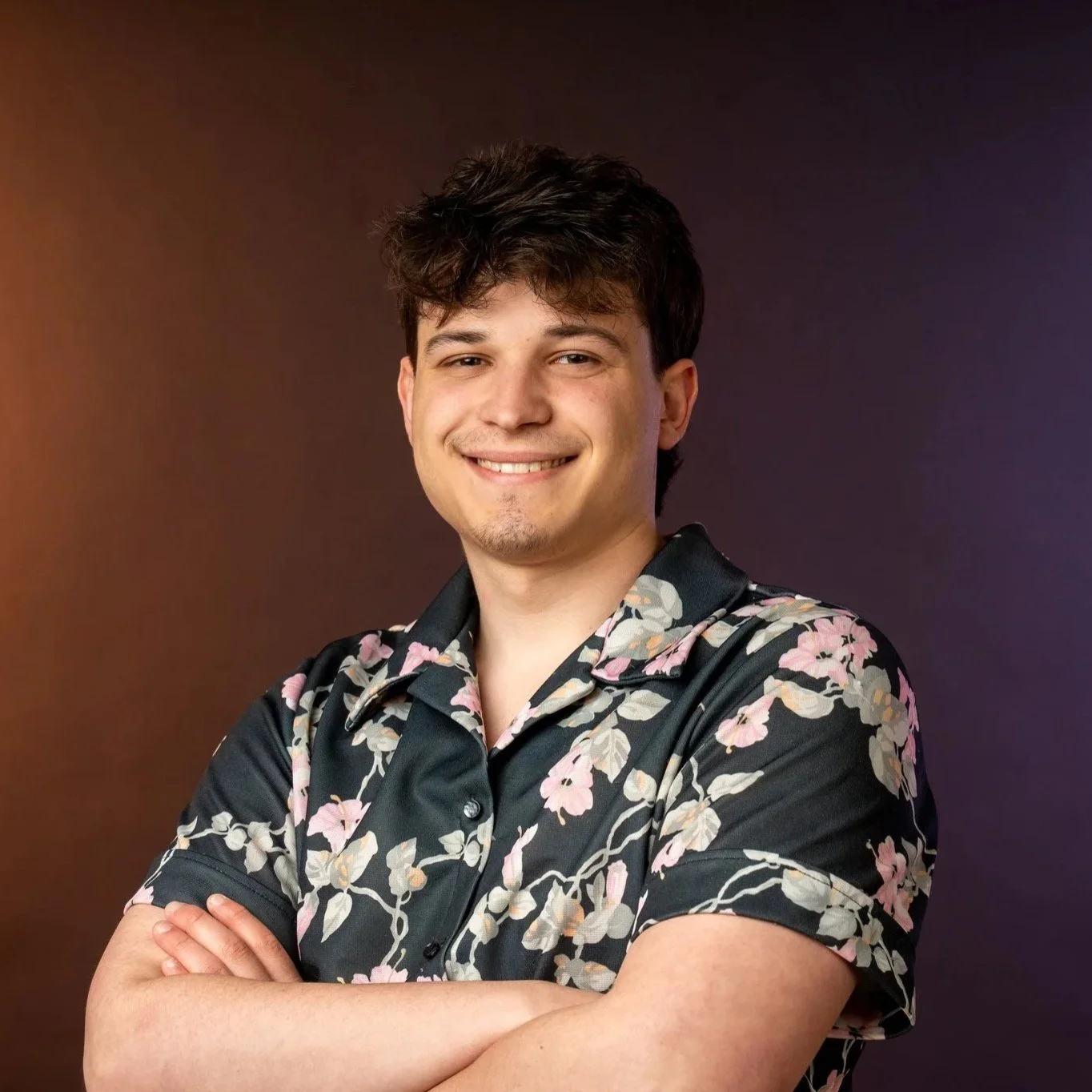 Bryce Yzaguirre's headshot photo. He is wearing a flower shirt and crossing his arms.