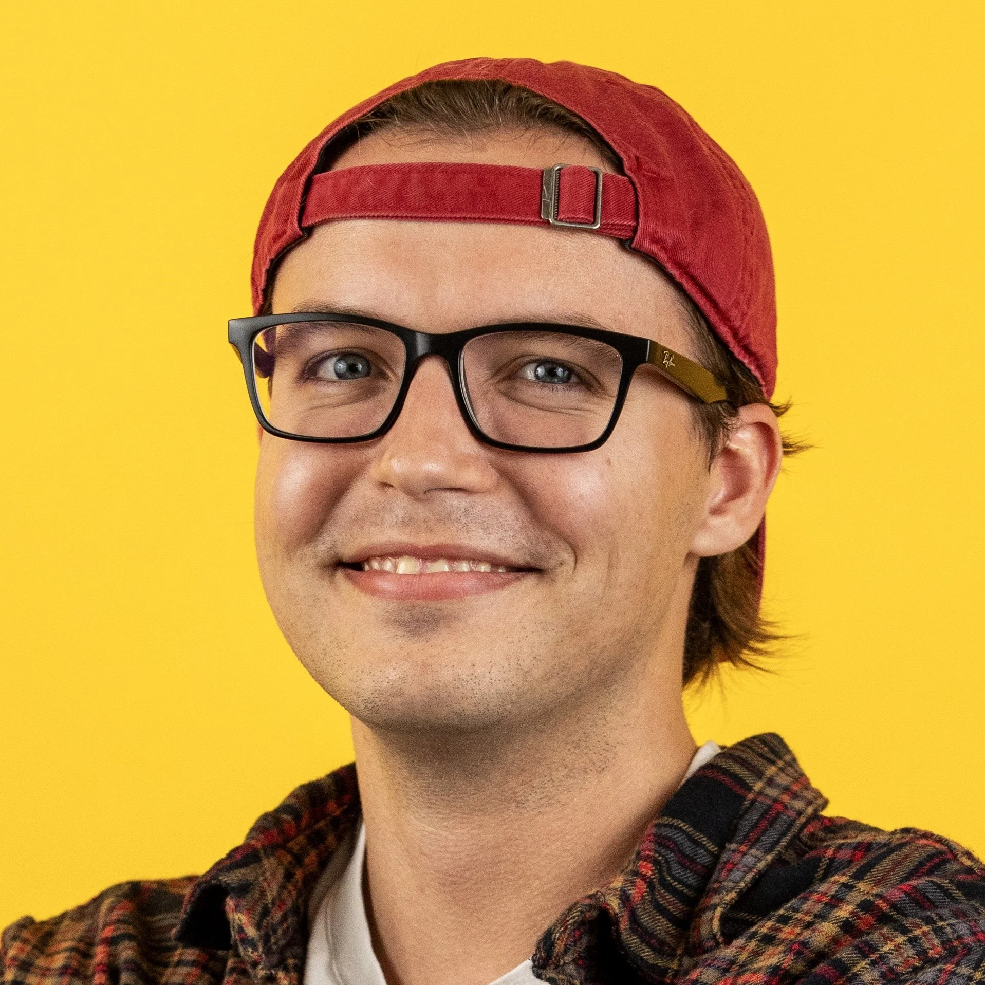 Breyden Boyd's headshot photo. He is wearing glasses and a tank top, and is giving a thumbs up. Shape-Man is in the background.