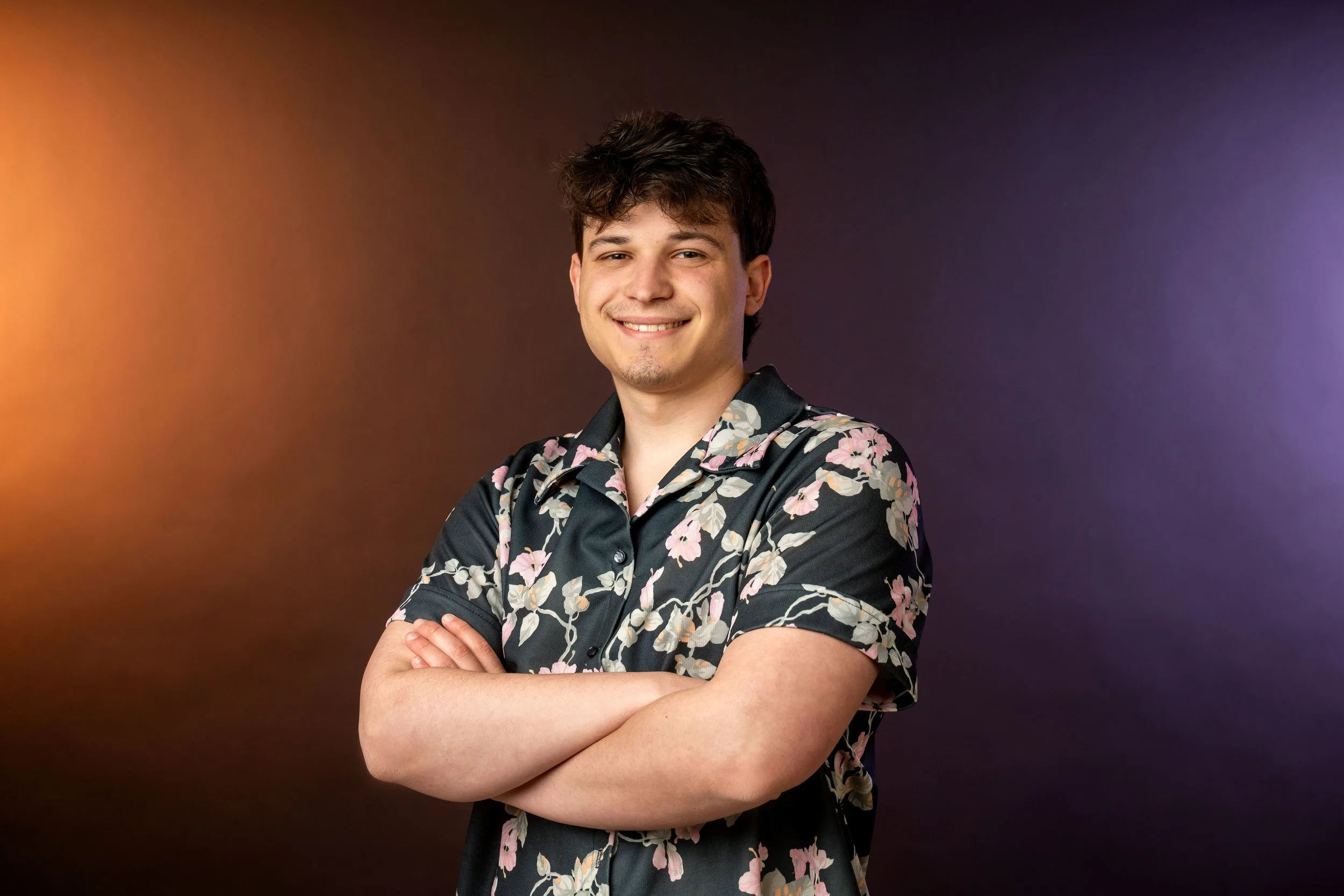 Bryce Yzaguirre's headshot photo. He is wearing a flower shirt and crossing his arms.